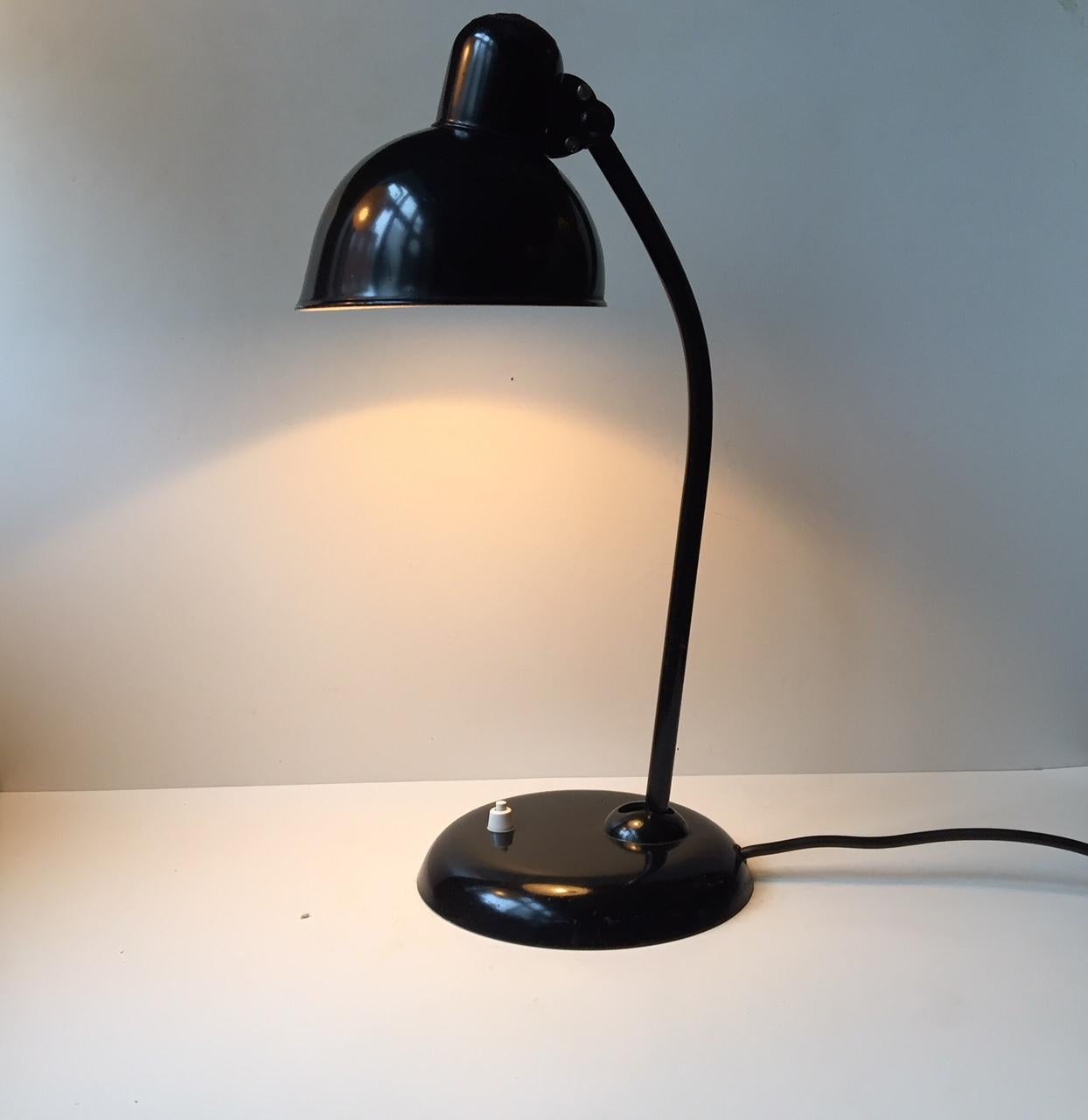 Kaiser Idell 6556 black desk lamp. This is the version with the smaller shade. Designed by iconic Bauhaus teacher Christian Dell. It features adjustable shade and vertically adjustable neck. It is unrestored and has its original lacquer and enamel.