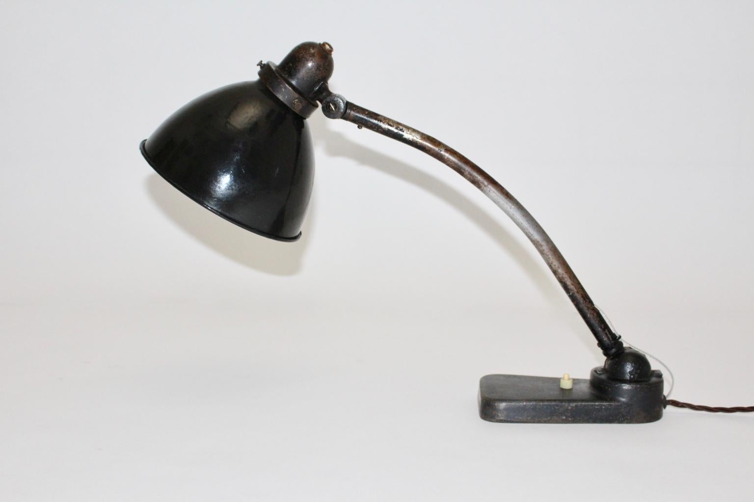 Lampe de table ou lampe d'architecte Bauhaus des années 1930 en Allemagne.
Une belle lampe de table en métal laqué noir, qui présente un abat-jour réglable de haut en bas.
Alors que l'abat-jour est en émail blanc et noir, la lampe de table est en