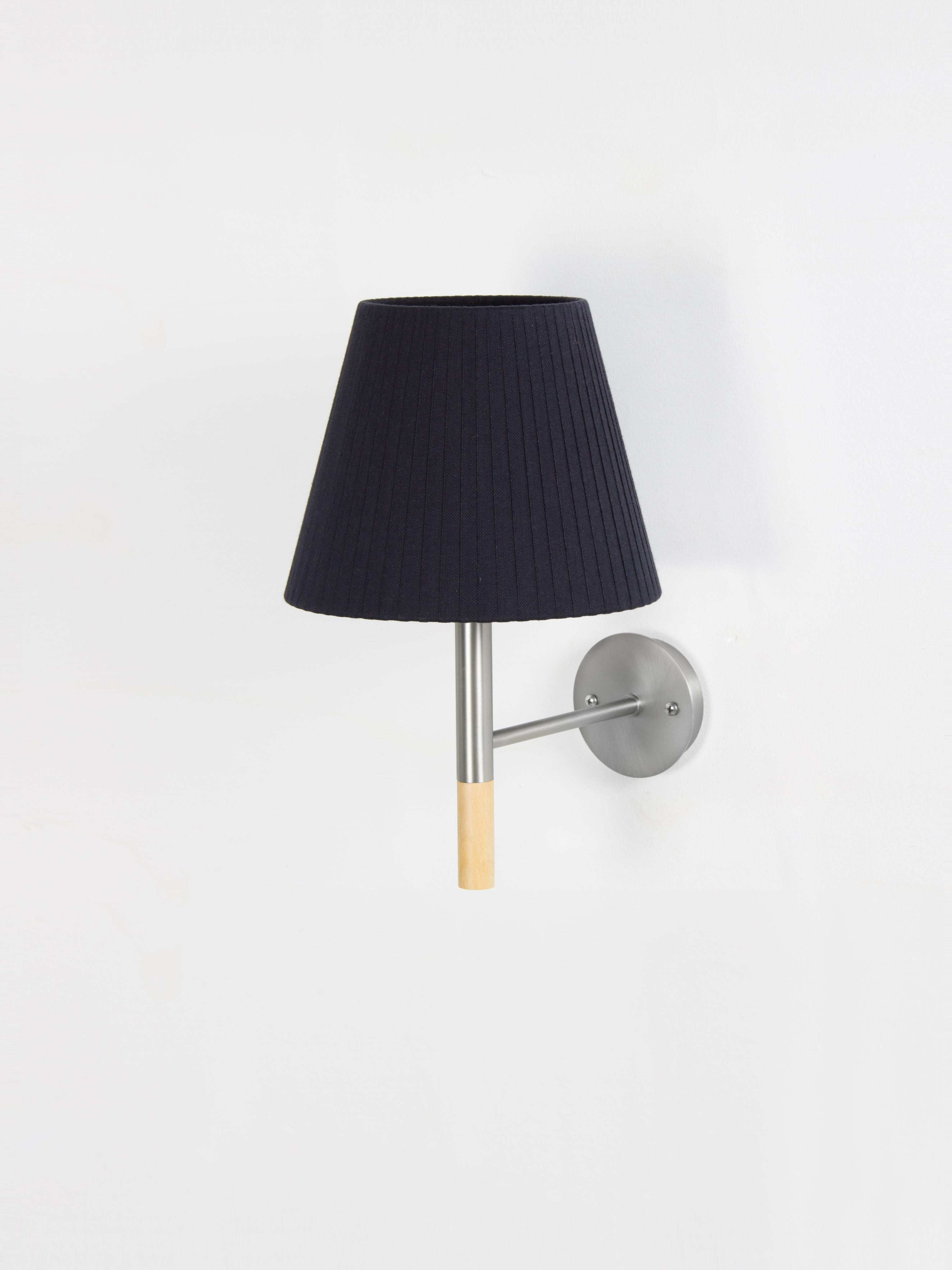 Black BC2 wall lamp by Santa & Cole
Dimensions: D 20 x W 26 x H 33 cm
Materials: Metal, beech wood, ribbon.

The BC1, BC2 and BC3 wall lamps are the epitome of sturdy construction, aesthetic sobriety and functional quality. Their various shade