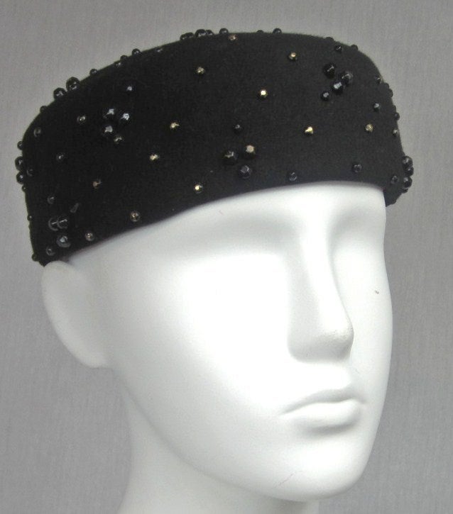 Wool Adolfo Hat. 1960s Black Studded Pill box Hat. Tiny beading scattered over the hat. 22.5 in diameter. Be sure to check our store front for more fabulous pieces from this collection. We have been selling this collection on 1st dibs since 2013.