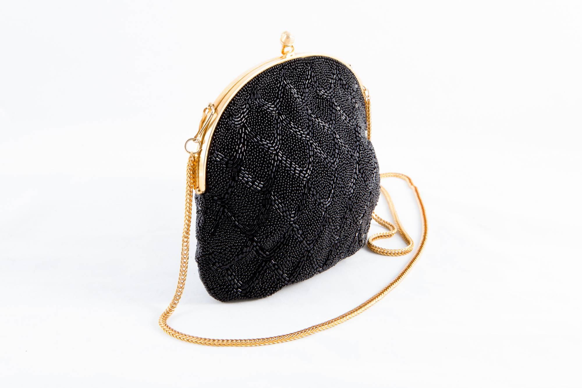 1960s Black beaded evening small tote bag featuring  a beaded design pattern,  a detachable chain handle ( total length:38,9 in. (99cm)), an inside silk lining. 
In excellent vintage condition. Made in France.
Measurements:
Length 7.8in. (20cm)