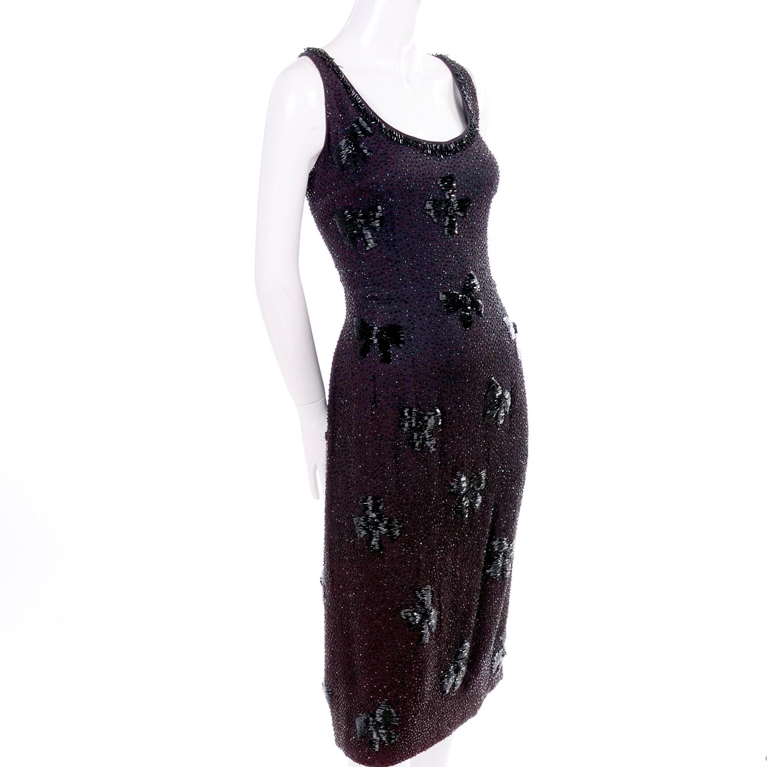 This is a beautiful black silk evening dress with lovely, intricate beading. The heavily beaded design creates a bow print across the dress! There are dangling bugle beads across the neckline and we estimate this dress to fit a modern day size