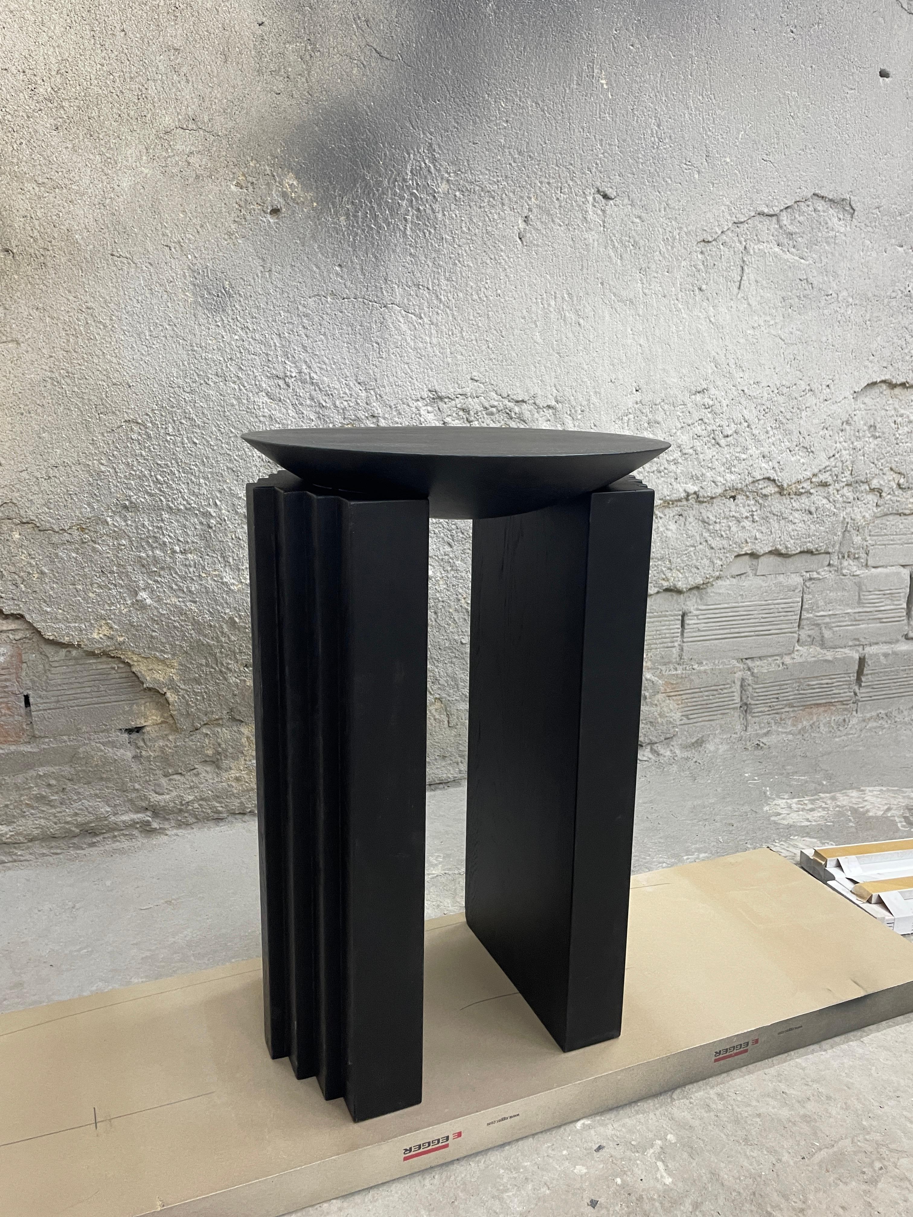 “Black beauty” is a sculptural side table in oak wood created by the artist Desia Ava. 
The piece features strong lines and gentle curves. Marked by architectural aesthetics, on the borderline between sculpture and furniture the solid wood has been