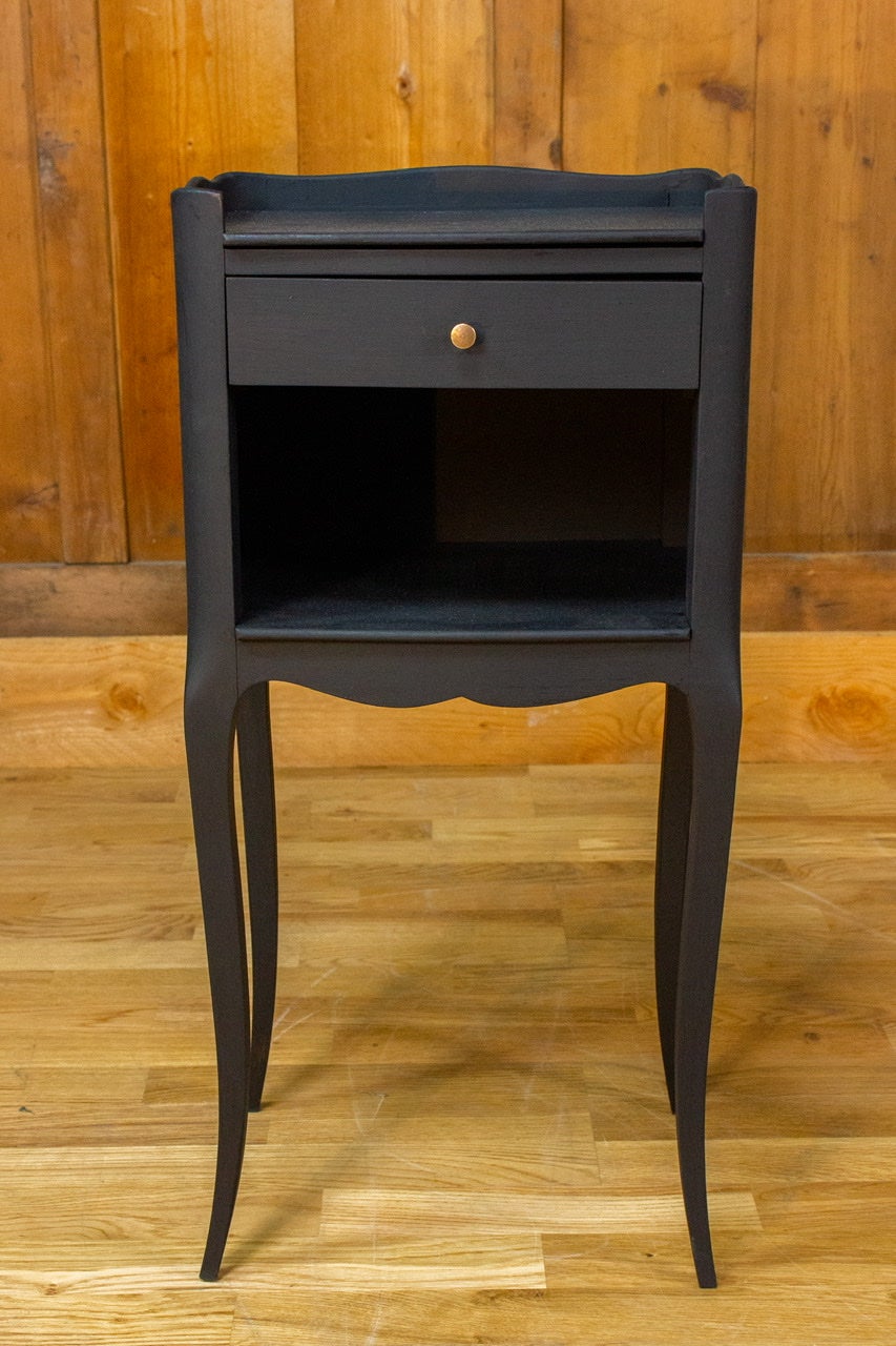 Very nice little black bedside table in the Louis XV style. The legs are slightly curved and the table is composed of one drawer and a shelf.