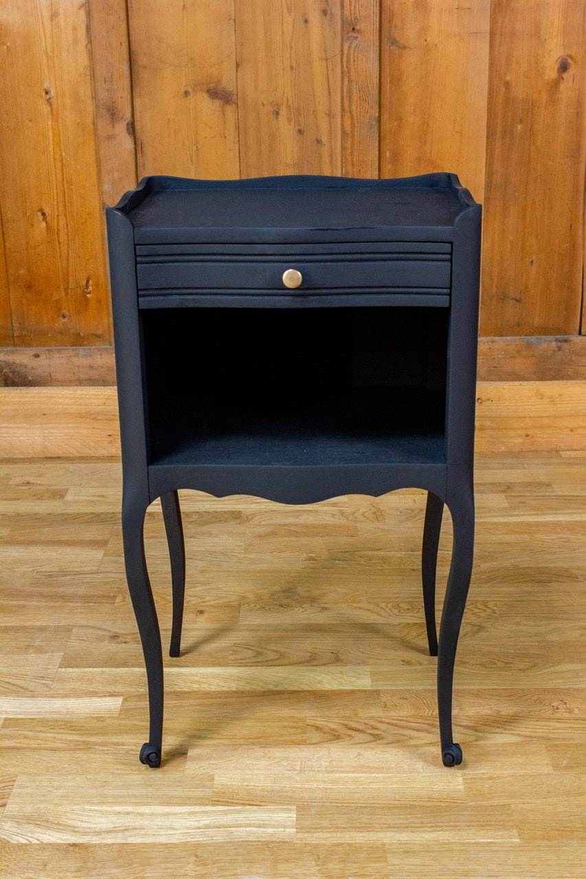Very nice little black bedside table in the Louis XV style. The legs are slightly curved and the table is composed of one drawer and a shelf.
