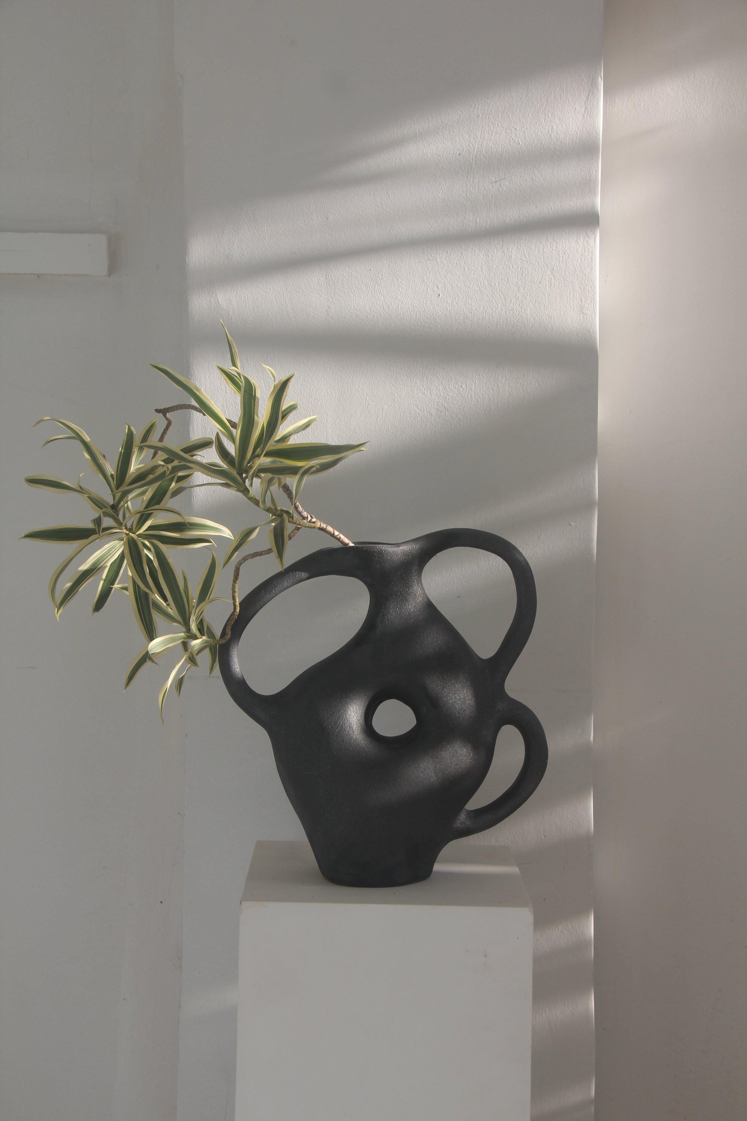 Grande vaso biomorfo nero in ceramica a 3 maniglie di Hanna Englund Ceramics. Progettato per stare da solo come pezzo centrale scultoreo o come vaso funzionale per composizioni floreali minimali.
Materiali: Ceramica. Gres scuro, rifinito con uno