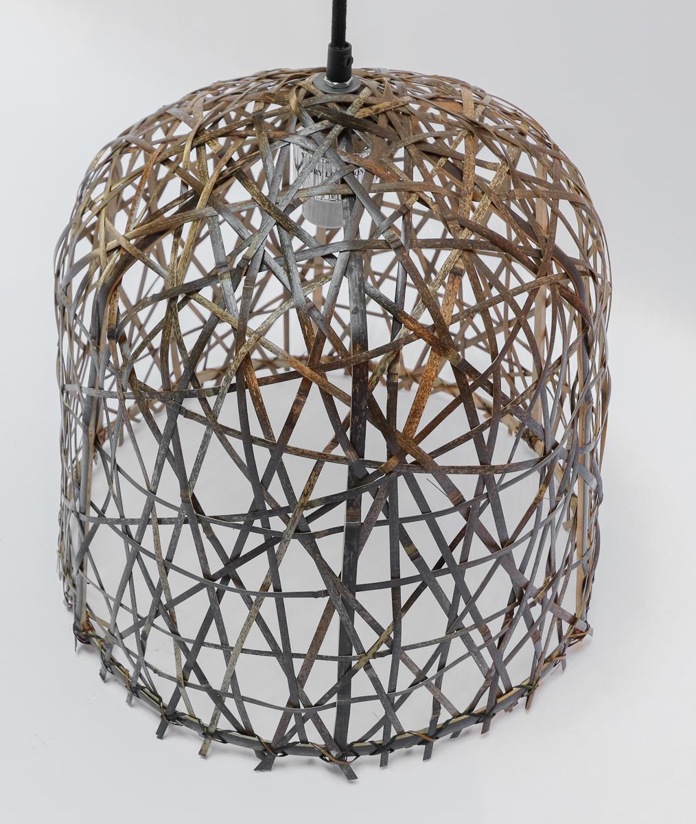 The inverted-cup shape of the Black Bird’s Nest small pendant has a shade woven from repurposed bamboo strips. It is the creation of Ay Illuminate, a company that has garnered quite a reputation for using this material as a building block for its