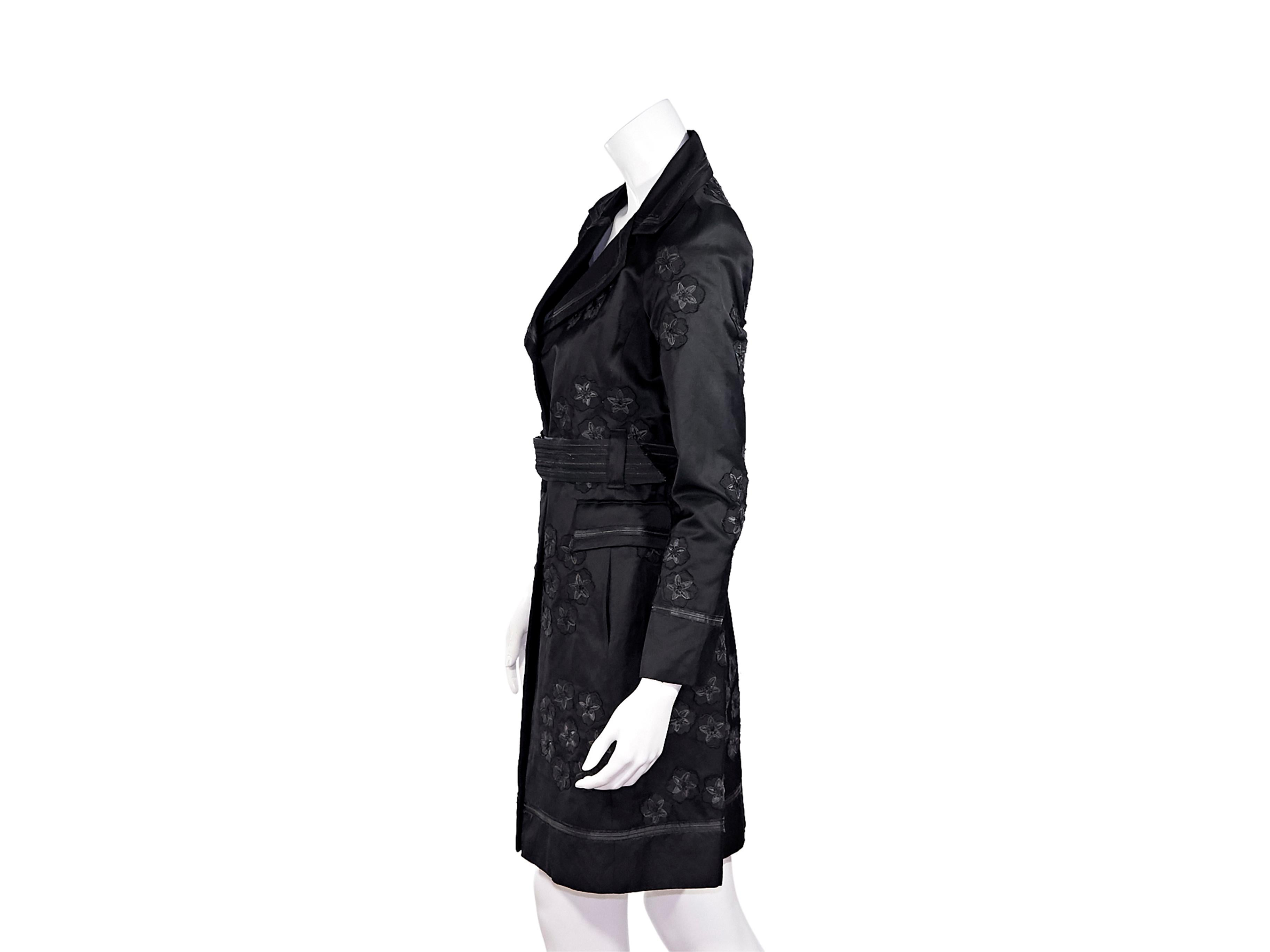Product details:  Black linen-blend trench coat by Biya.  Adorn with floral applique.  Notched lapel.  Long sleeves.  Button-front closure.  Adjustable belted waist.  Waist flap pockets.  40