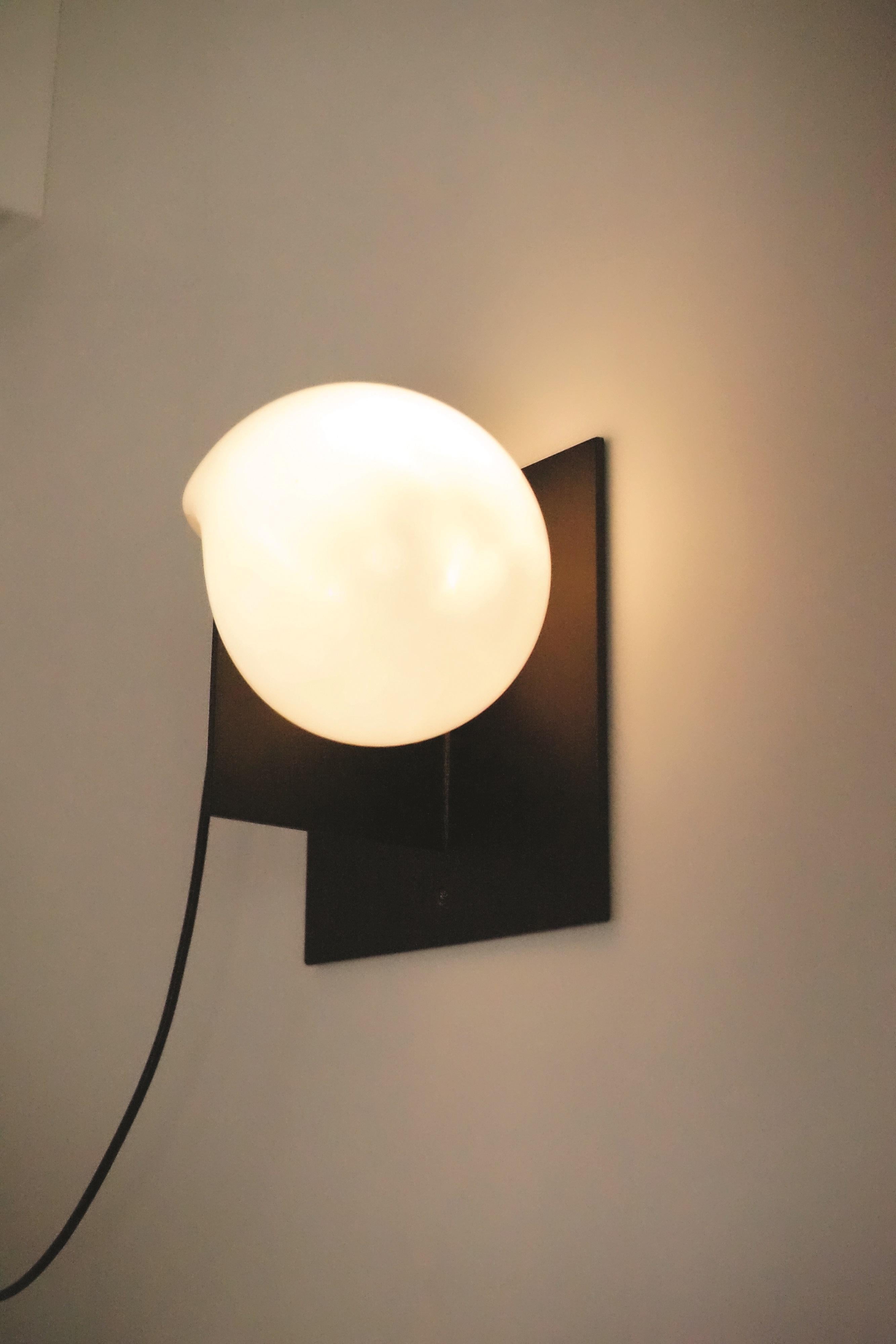 Black bloop sconce by Nick Pourfard.
Dimensions: D 15.5 x W 25.5 x H 25.5 cm.
Materials: metal, glass.
Different finishes available. 

All our lamps can be wired according to each country. If sold to the USA it will be wired for the USA for