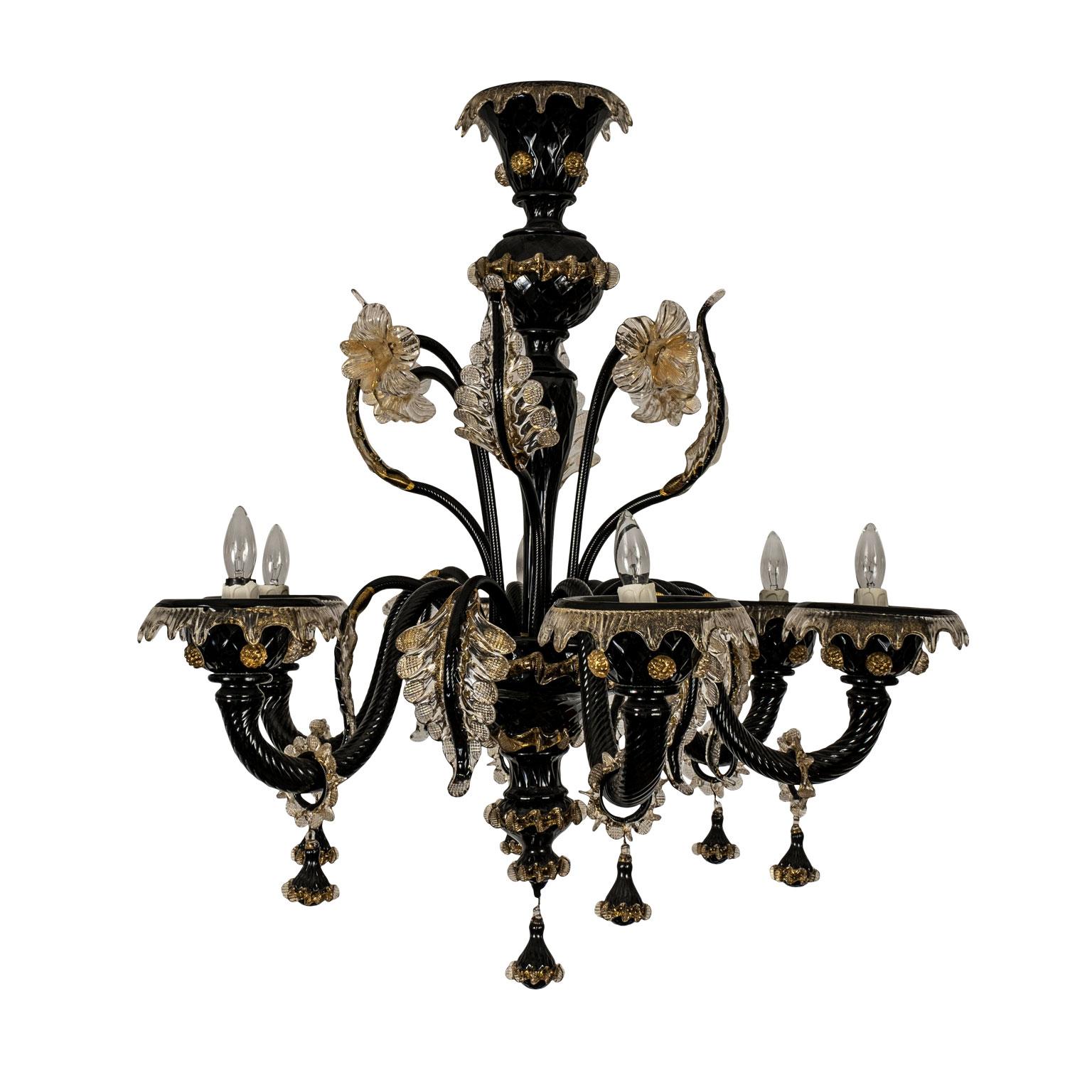 Vintage black glass Murano chandelier decorated in clear and gold glass embellishments. Six candelabra-size lights wired for use within the USA, circa 1970-1990. Retains original gilt brass chain and black glass canopy.