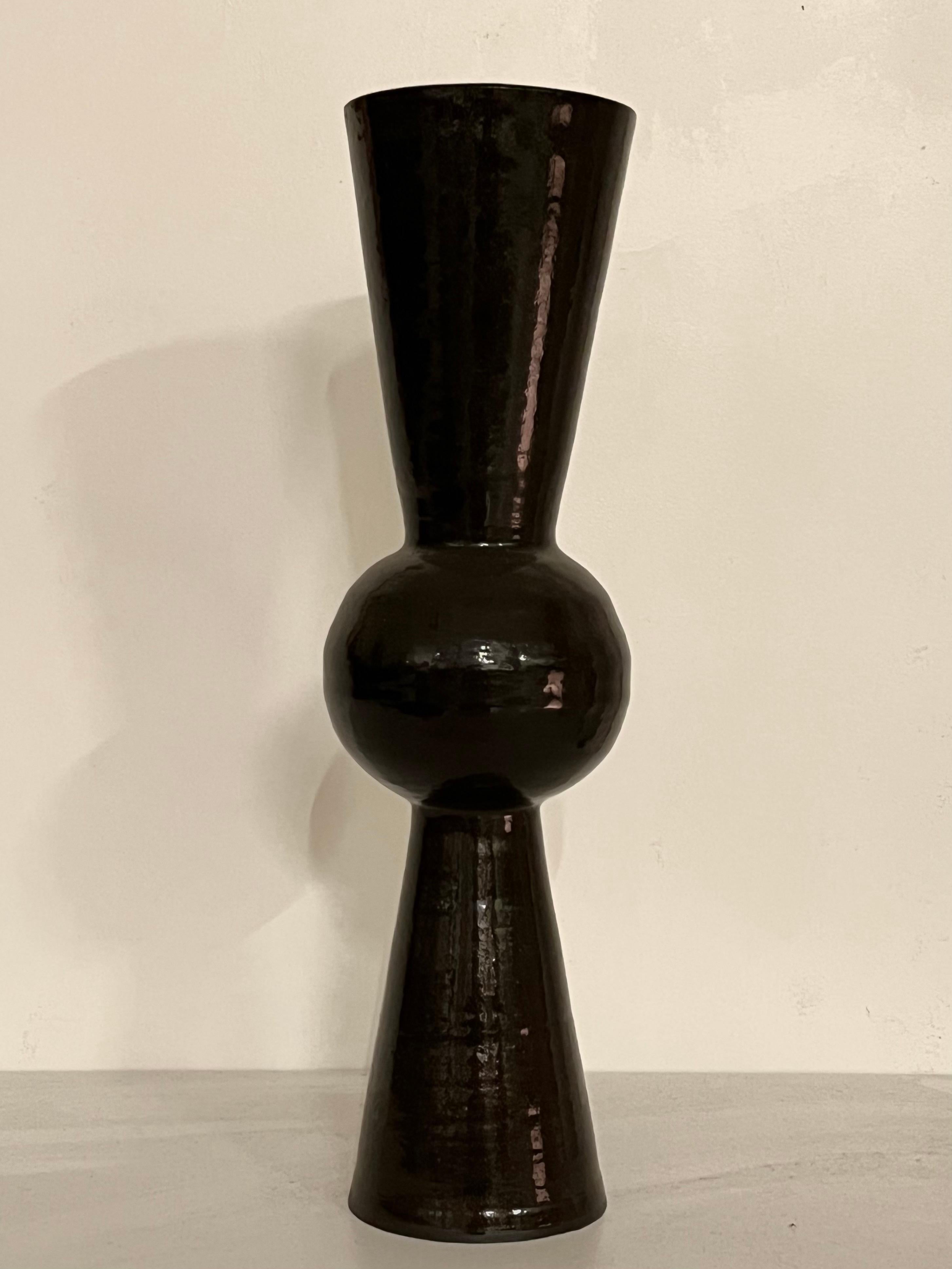 Black Bonbon vase by Solem Ceramics.
Dimensions: Ø 12.7 x H 34.5 cm.
Materials: stoneware, glaze.
This vase is water safe.

Solem’s work pulls from memories of the architecture and community within SWANA and Southeast Asia thorough exploring