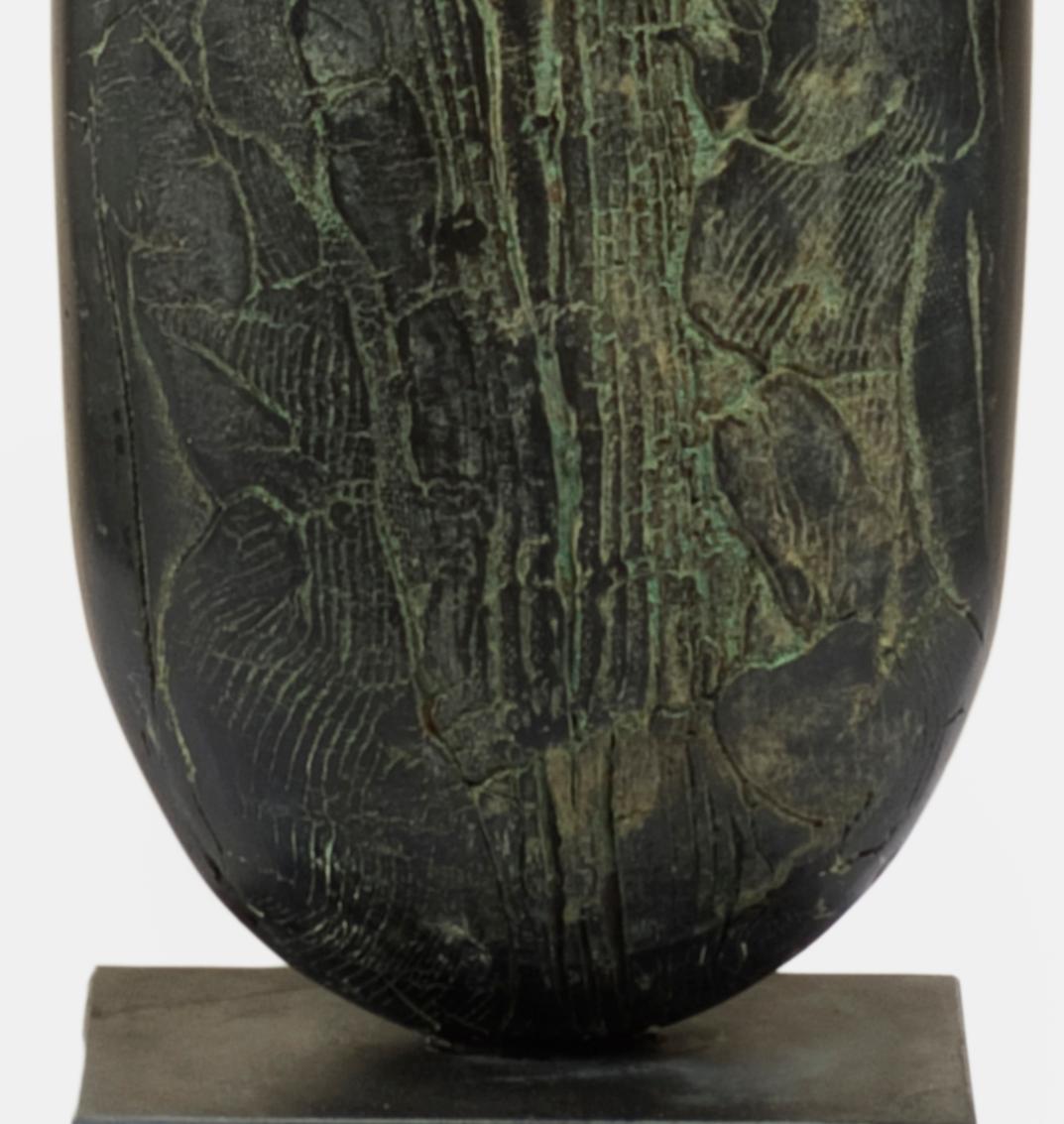 This obelisk shaped object is completely handmade, fired ceramic. The black surface is textured with ridges and grooves which have a green patina due to a natural aging process the artist uses. 

Peter Hayes
Black bottle
ceramic
Measures: 41 H