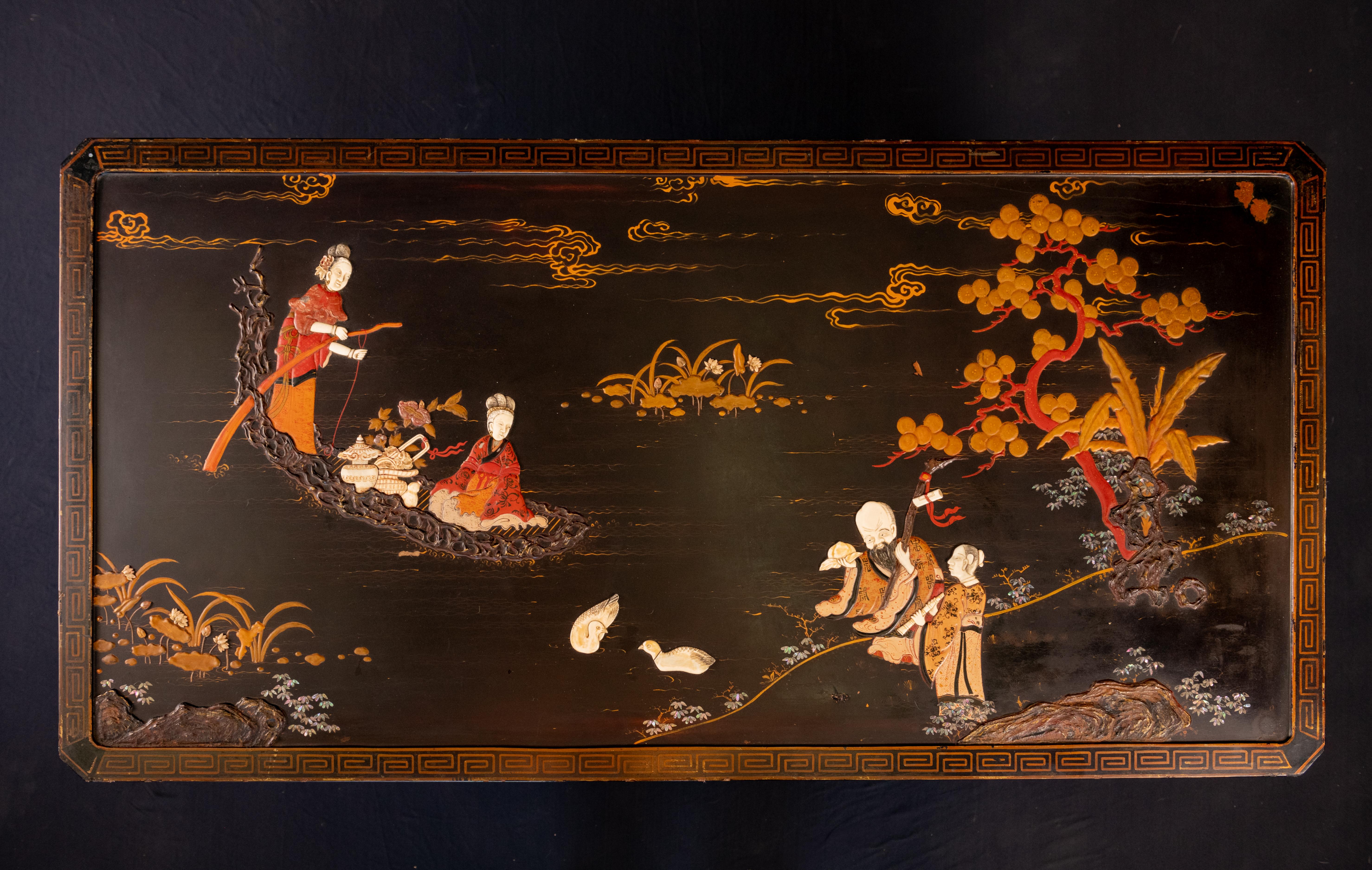 Exceptional vintage Mid-century chinoiserie black lacquered rectangular coffee table. Features a Greek Key border which is a nod to its Hollywood Regency influences. The table is hand carved and inlaid with mother of pearl and stones. and has a
