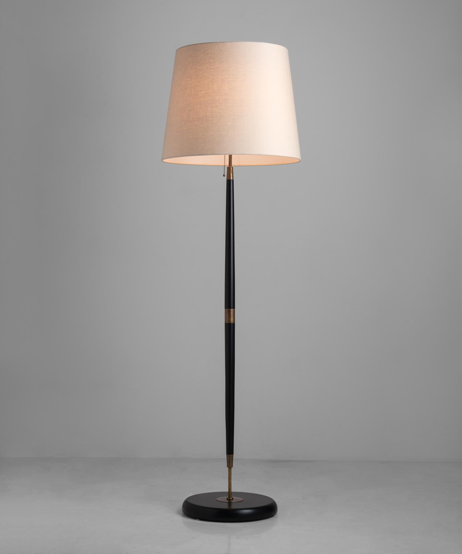 An oval shade sits atop a black wooden base and slightly tapered stand with brass detailing throughout.

Available in quantity.

*Please Note: This fixture is made to order in Italy, and comes newly wired (eu wiring). It is not UL Listed. Standard