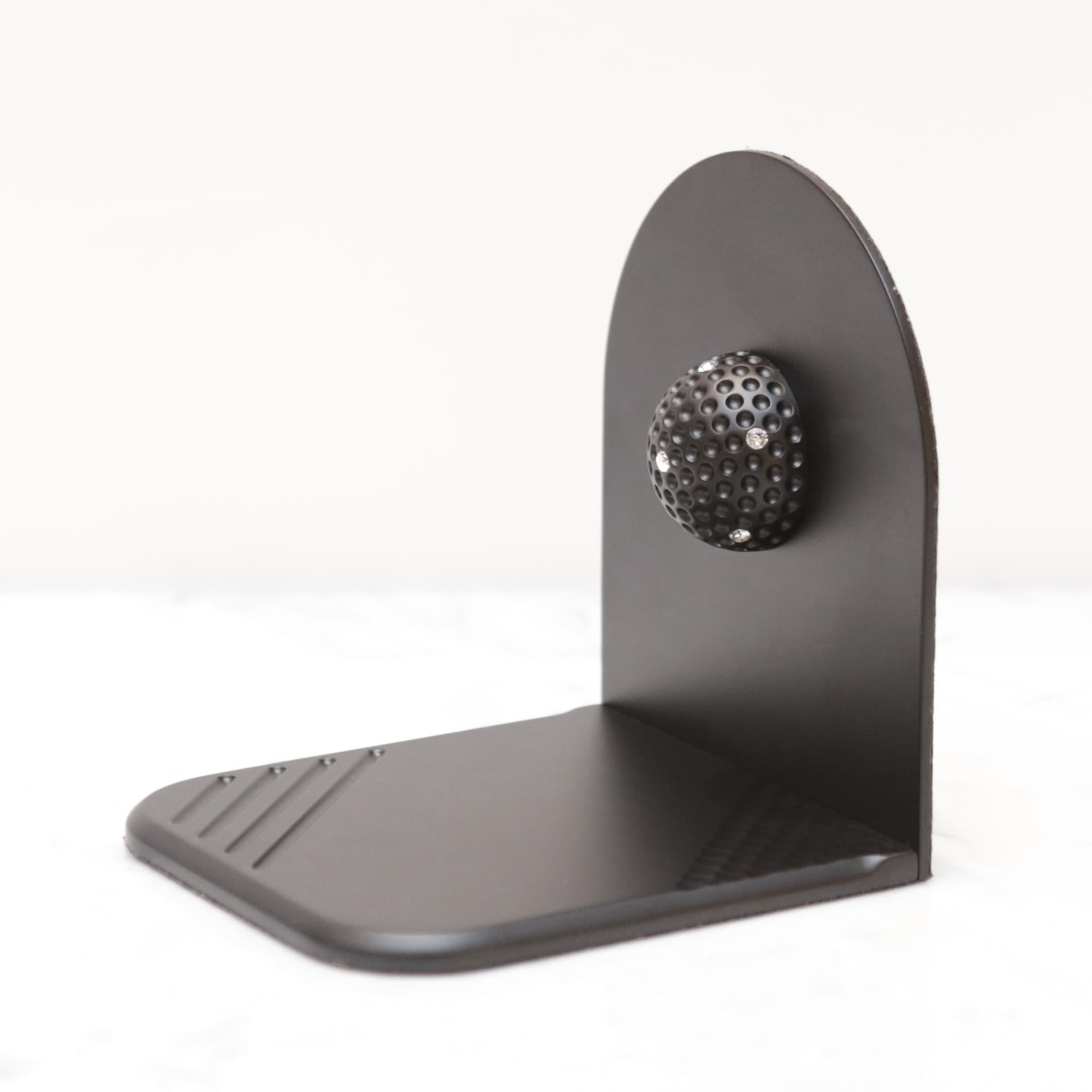 Fermalibri in ottone nero con set di 2 golfisti in legno massiccio
in ottone con finitura nera opaca. Con mezza pallina da golf addosso
ogni libro è dotato di cristalli.
Misure: L 9 x P 9 x H 10, 3 cm ciascuna.
Disponibile anche in bronzo bianco.