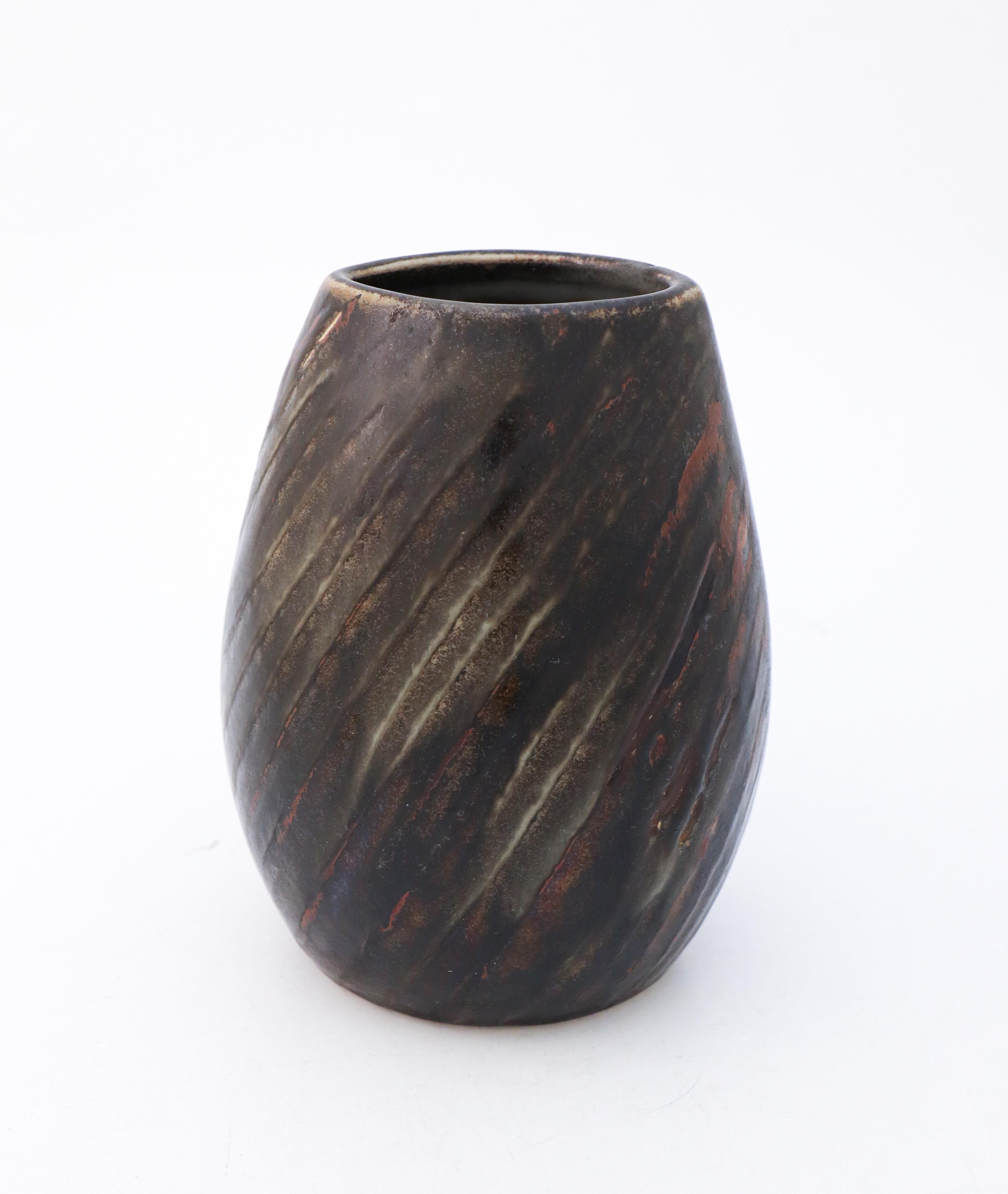 Vase noir et brun conçu par Carl-Harry Stålhane à l'atelier Rörstrand. Il mesure 21 cm de haut et environ 14,5 x 12 cm de diamètre. Elle est en excellent état. Il est indiqué qu'il s'agit d'un produit de deuxième qualité, mais je ne vois pas