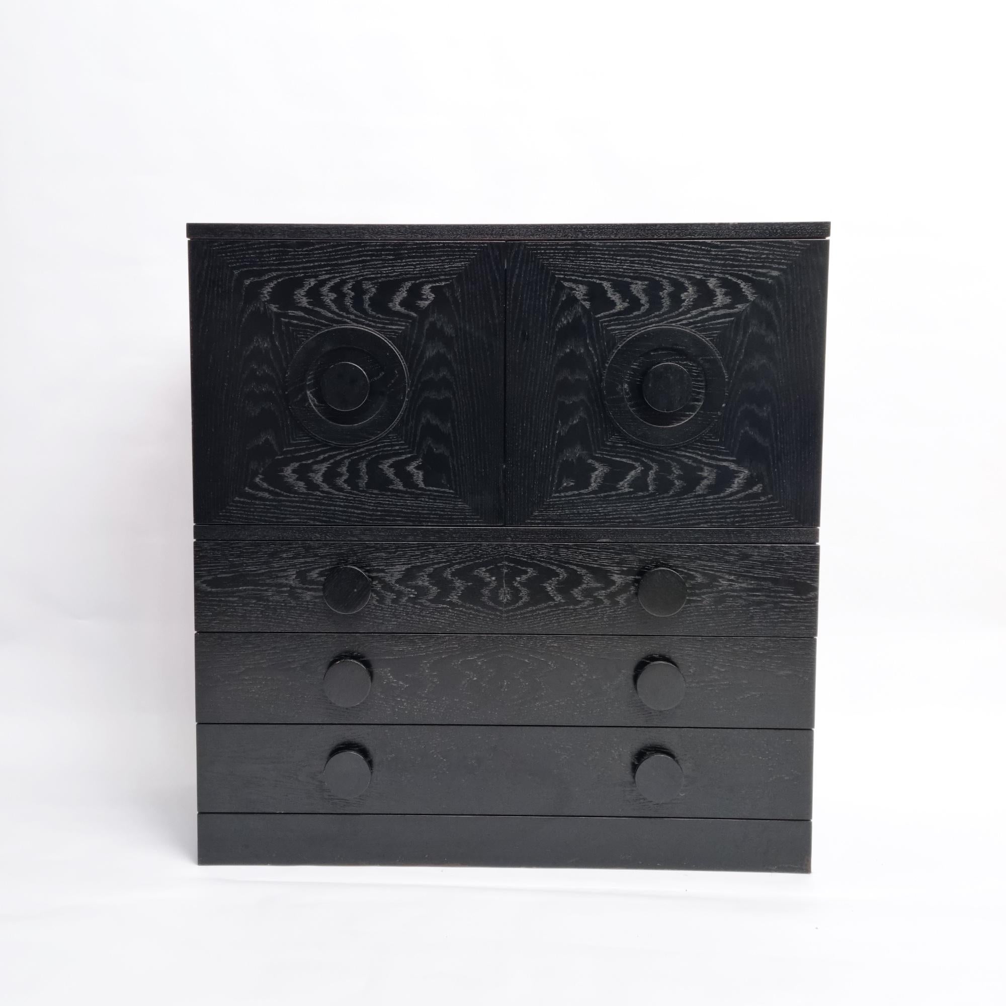 Dieser auffällige schwarze Barschrank im Brutalismus, der in den 1970er Jahren in Belgien hergestellt wurde, ist ein beeindruckendes Beispiel für minimalistisches Design. Das aus schwarz lackierter Eiche gefertigte Sideboard verfügt über zwei Türen