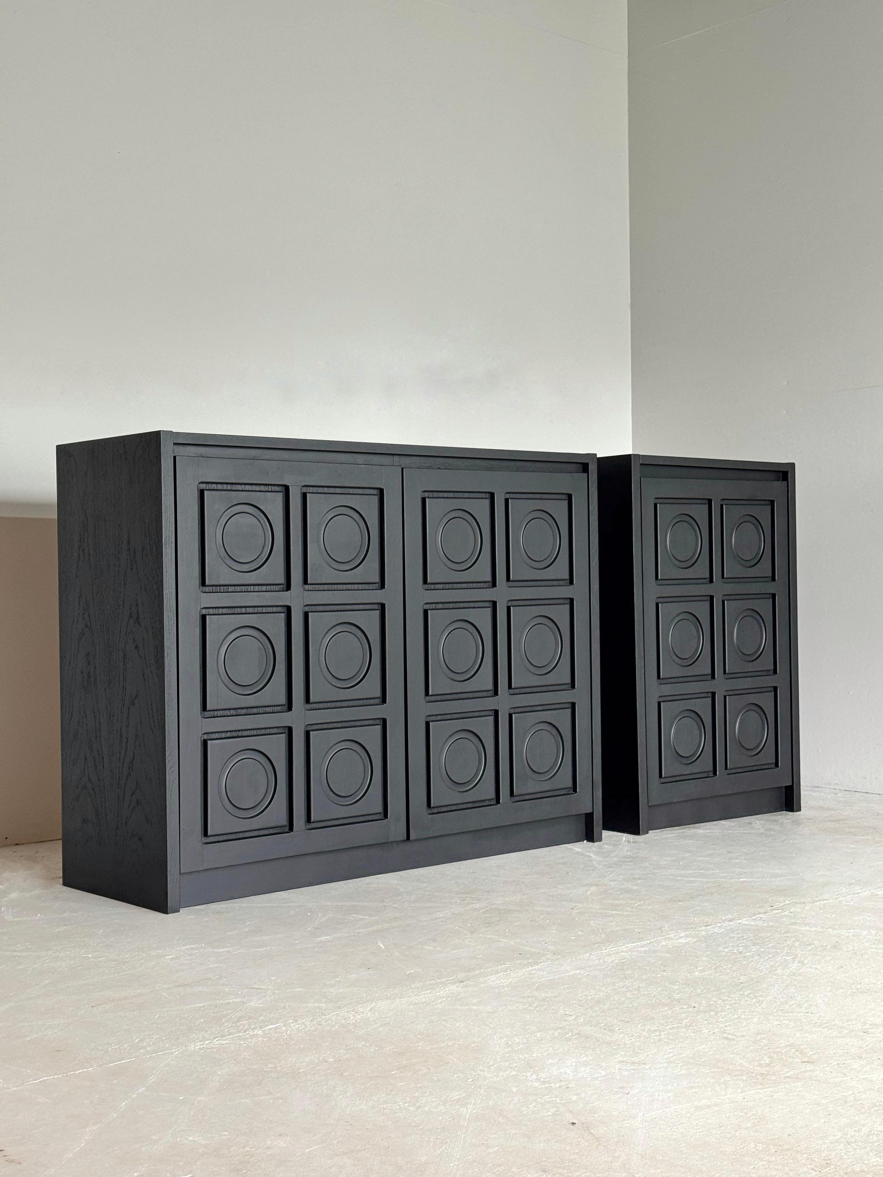 Ensemble d'armoires brutalistes noires statiques combinant une armoire à 2 portes et une armoire à 1 porte avec des panneaux de porte ronds et graphiques.

Les deux armoires ont été entièrement restaurées et ont reçu une nouvelle peinture.

En