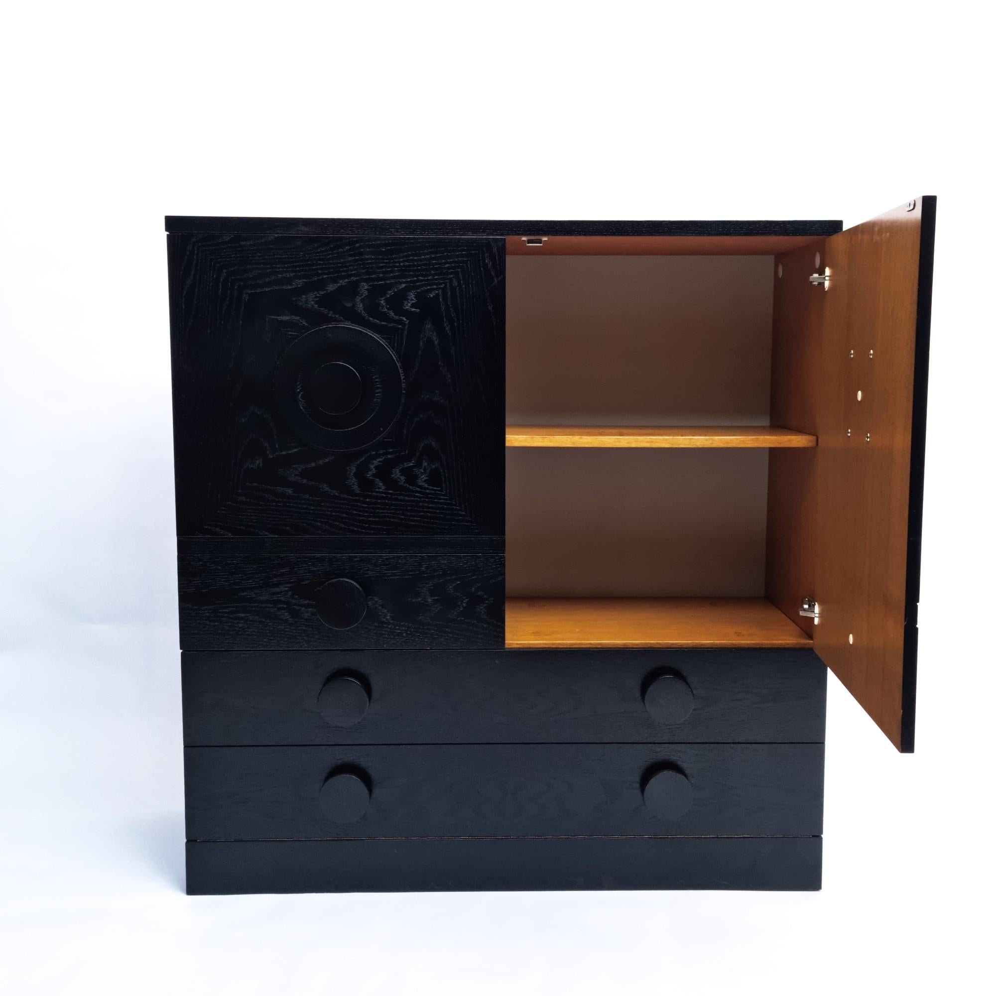 Black Brutalist bar cabinet in black lacquered oak, Belgium 1970s.

Sideboard features three graphic patterned doors. It provides plenty of storage which makes it both very functional and decorative. These cabinets are often attributed to Belgian