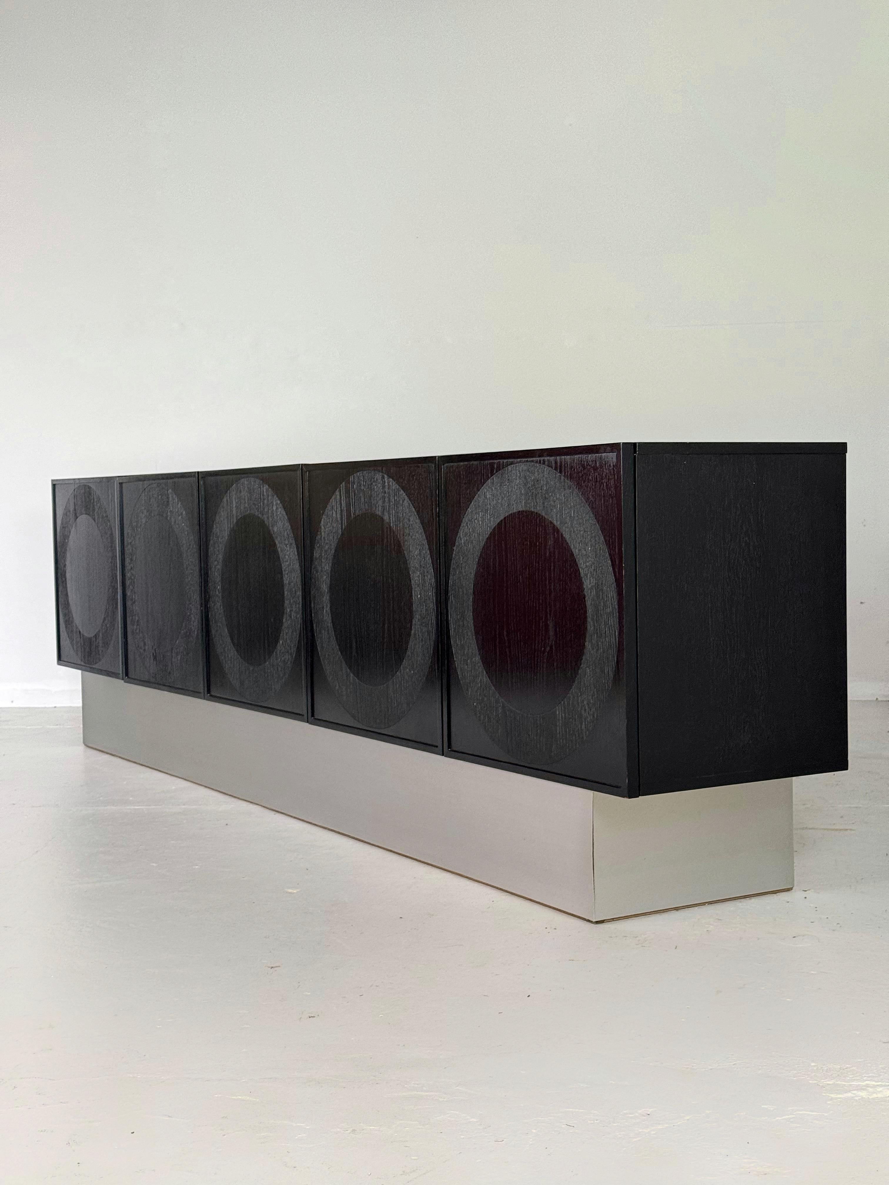 Aparador brutalista negro gigante con motivos circulares, diseñado y fabricado por Musterring, Bélgica.

En muy buen estado y con mucho espacio de almacenamiento en el interior.

5 puertas.

Dimensiones

Altura 77 cm

Profundidad 46cm

Anchura 275 cm