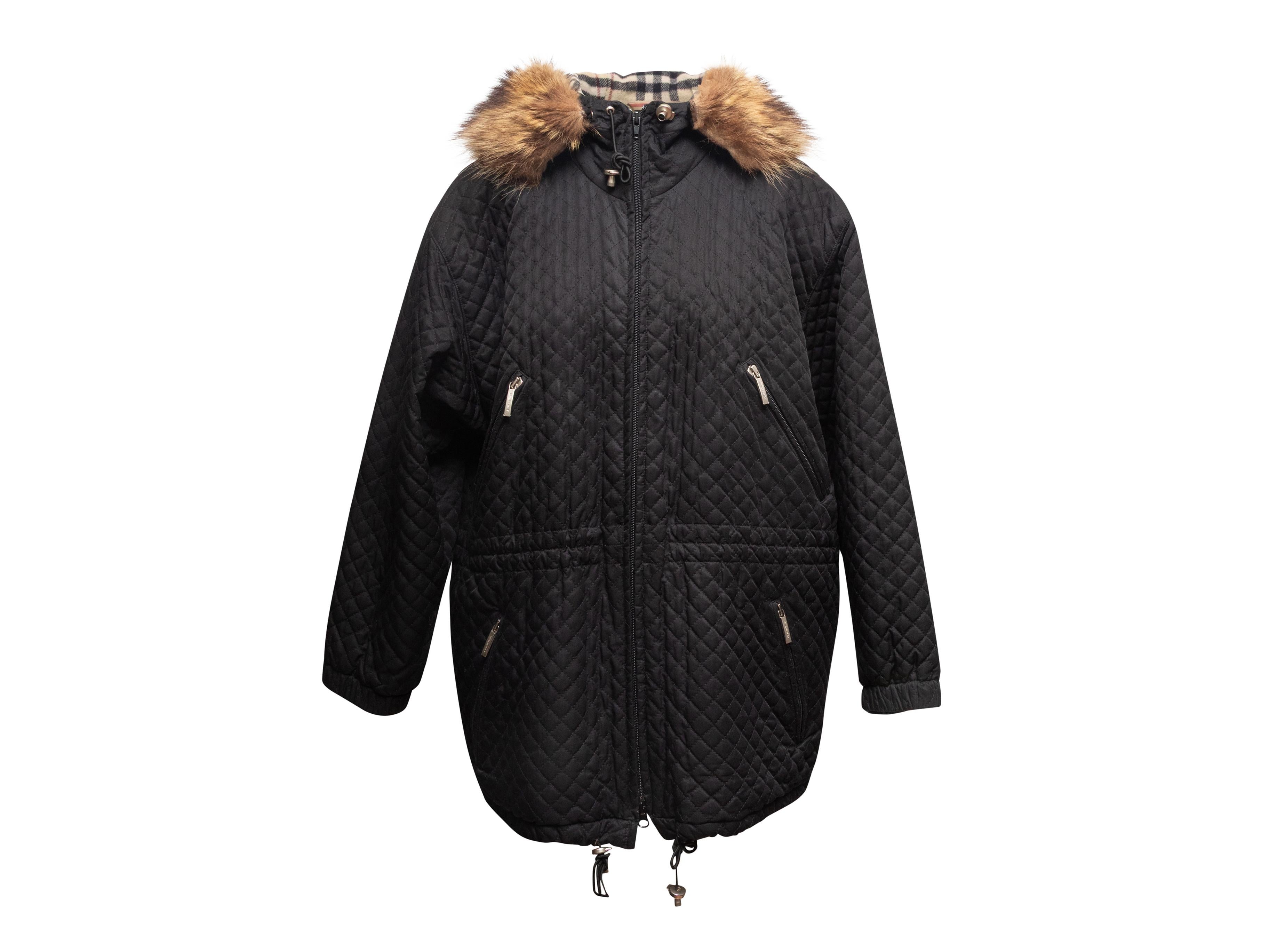 Cappotto trapuntato nero con cappuccio foderato in lana di Burberry. Profili in pelliccia sul cappuccio. Fodera interna in Nova Check. Quattro tasche anteriori. Chiusura frontale con zip. Seno 42