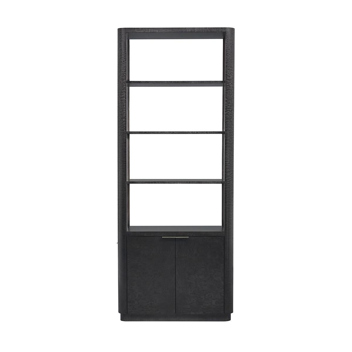 Handcrafted in a stunning Tamo ash burl veneer, this bookcase showcases the intricate and unique grain patterns of the wood, exuding luxury and timeless style. The deep silent black finish complements the natural beauty of the burl, while the Brass