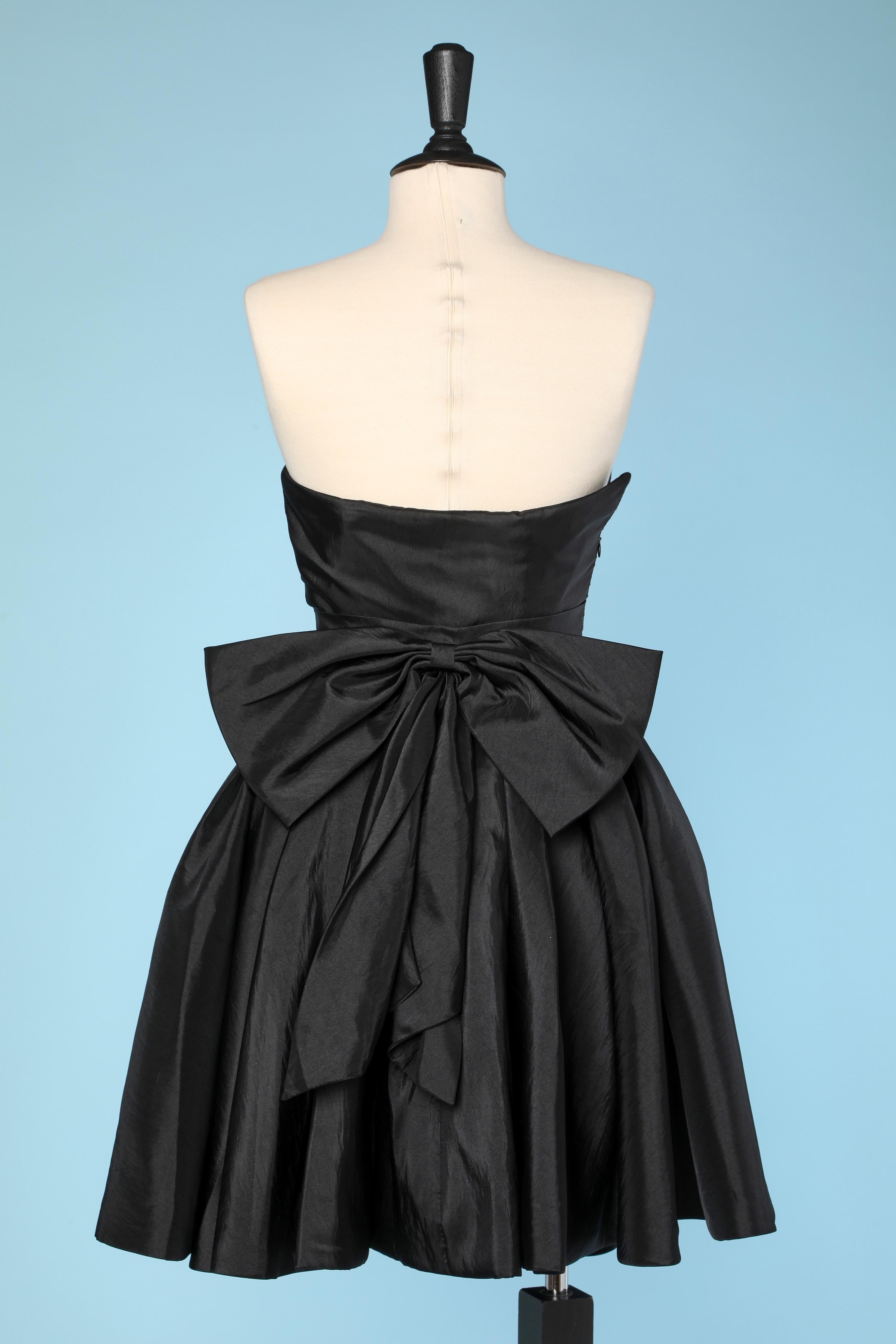 Black bustier cocktail dress in silk Faille with bow in the back.
Zip on the right side. Padded bra. Boned. Elastic band behind the bust ( like a bra)
SIZE S
