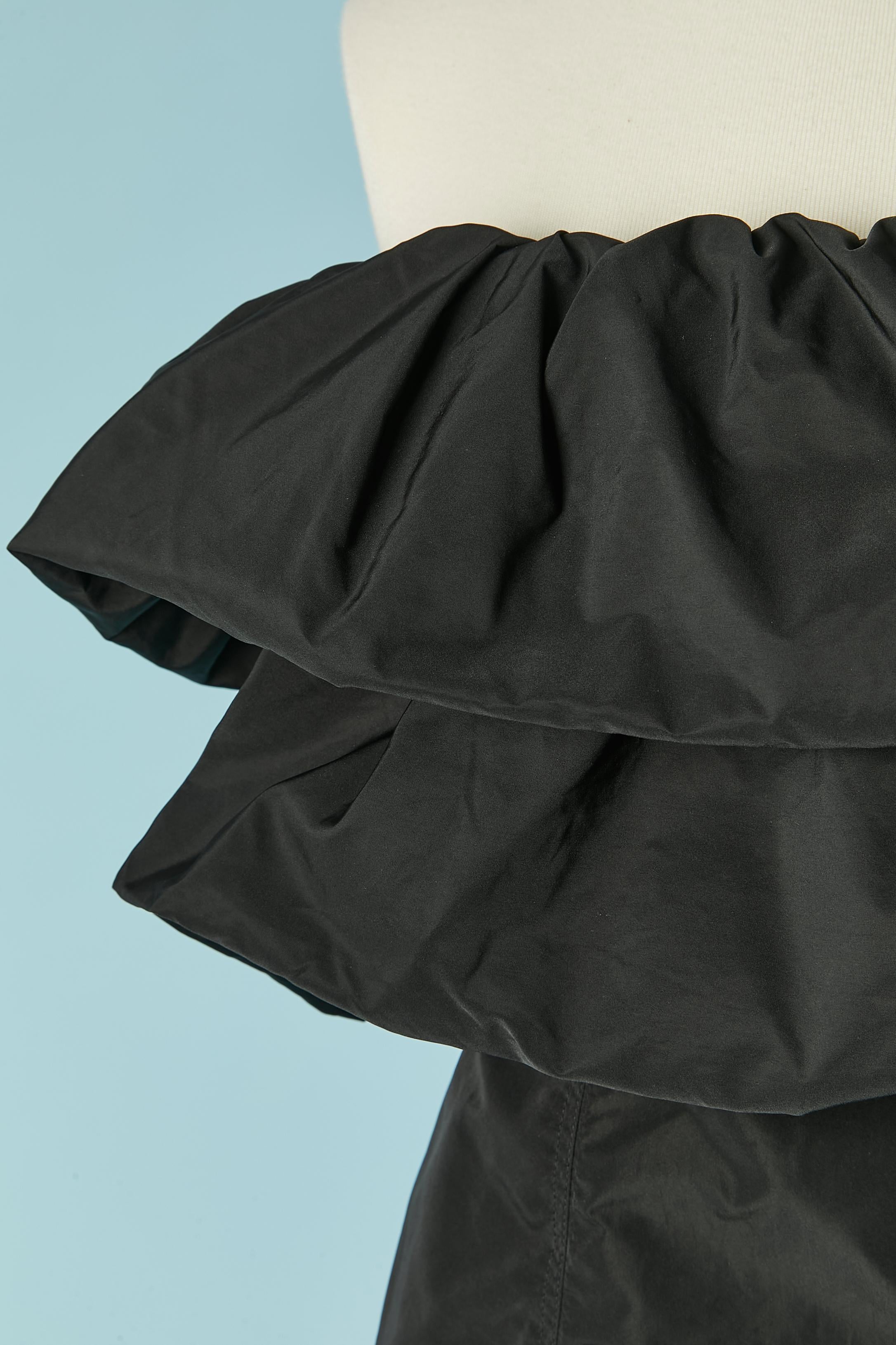 Black bustier with ruffles with zip and snaps closure on the middle back. Another boned bustier inside with hook and eye closure and gros-grain piping. No fabric composition tag. SAMPLE.
SIZE XXS 
