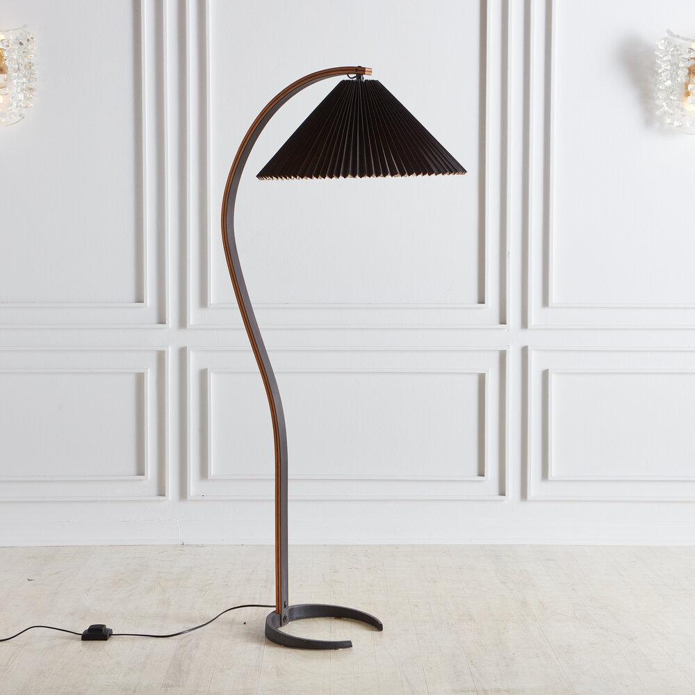 A Danish bentwood floor lamp designed in the 1970’s for Caprani of Denmark. Featuring its original shade custom made in Denmark, a C shaped metal base, a gorgeous painted black bentwood frame and a floor switch. Makers mark is stamped into the metal