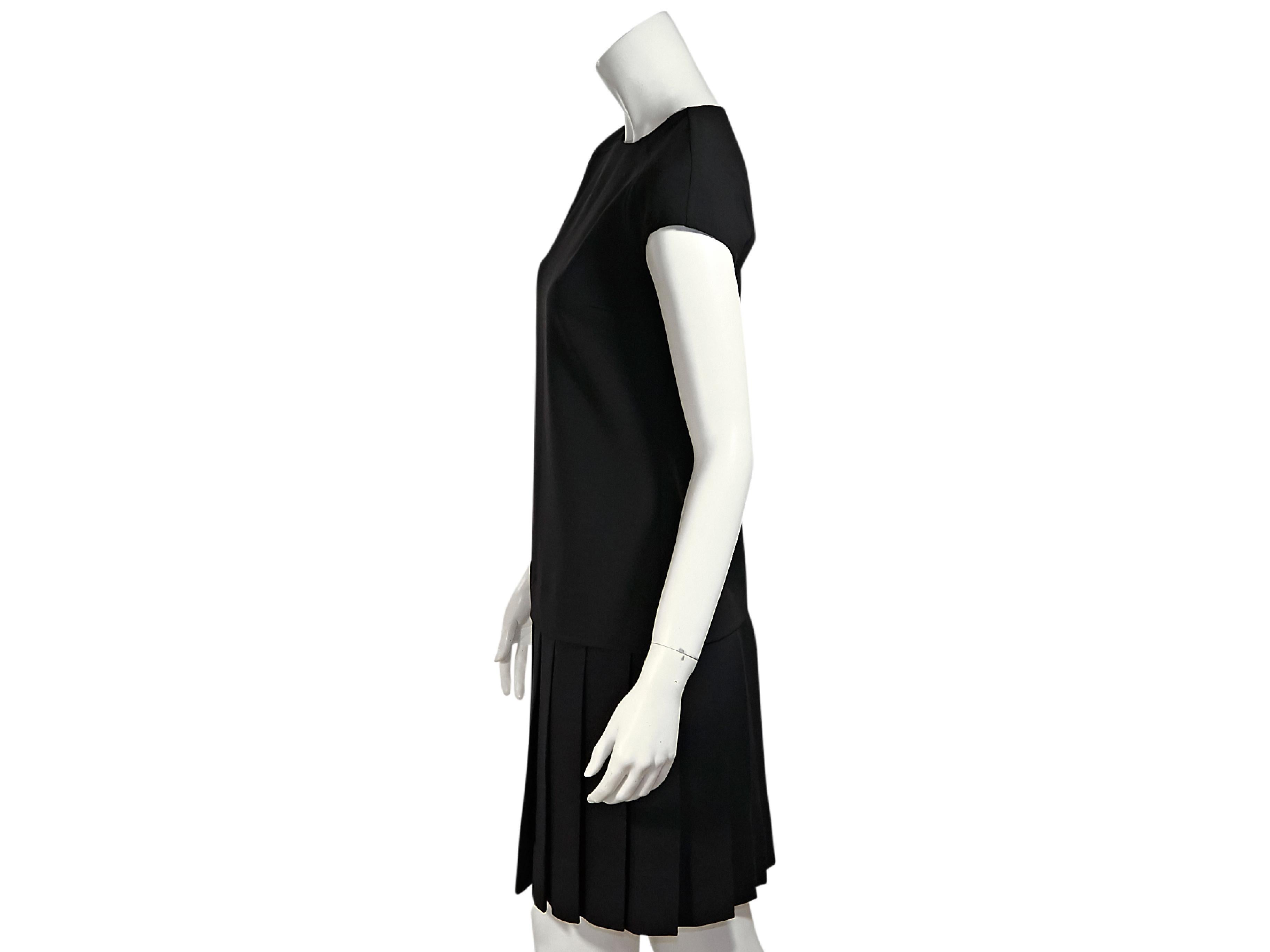 Product details:  Black stretch-wool drop waist dress by Carolina Herrera.  Roundneck.  Cap sleeves.  Concealed back zip closure.  Pleated skirting.  32