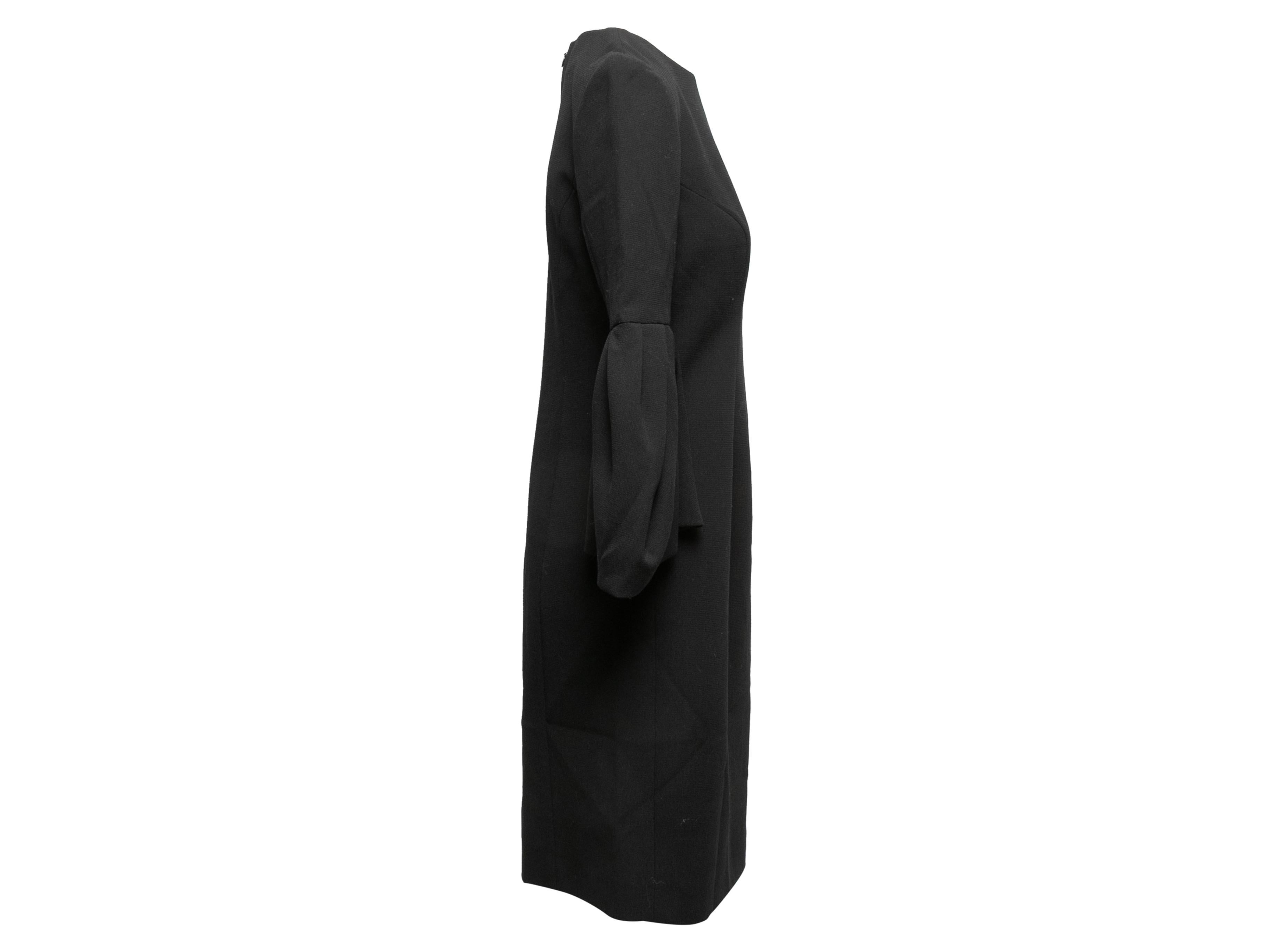 Black virgin wool dress by Carolina Herrera. Crew neck. Long puff sleeves. Zip closure at back. 37