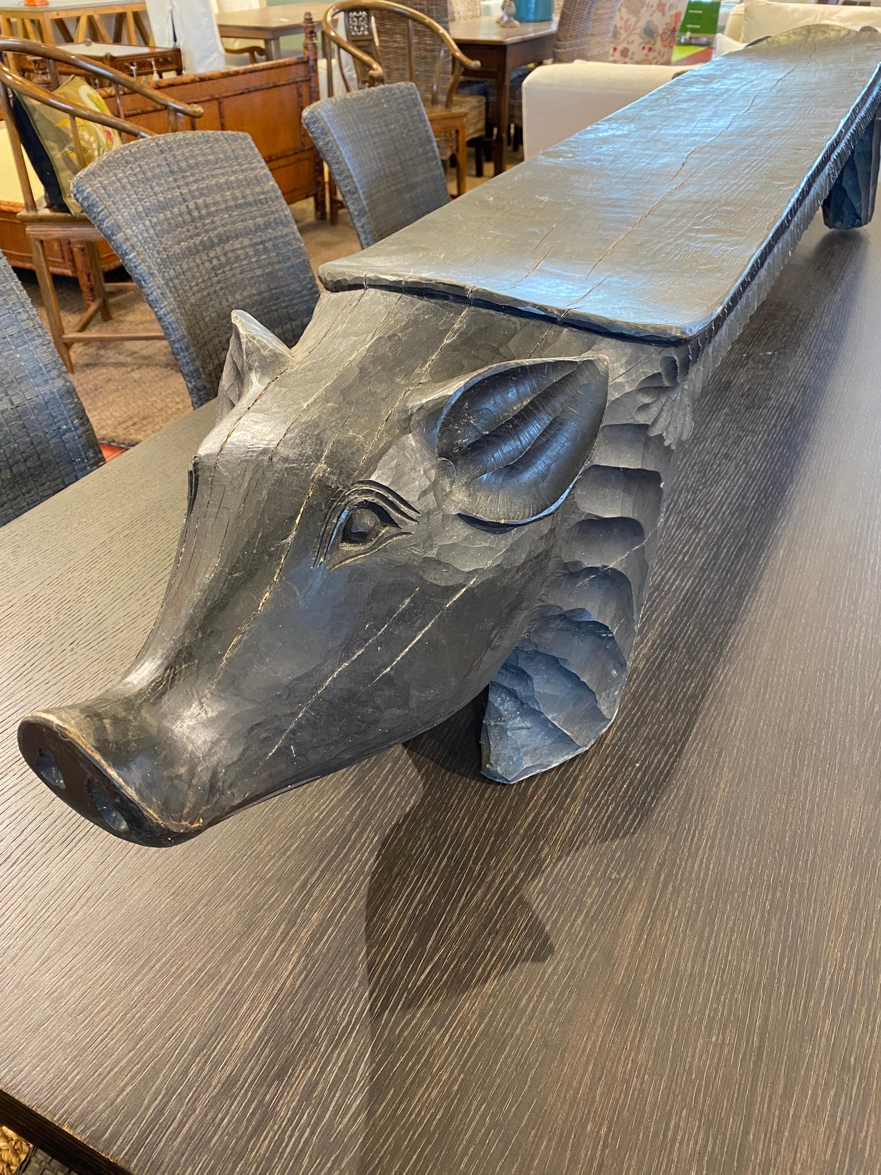 Black carved bench with pig heads

Measures: 90