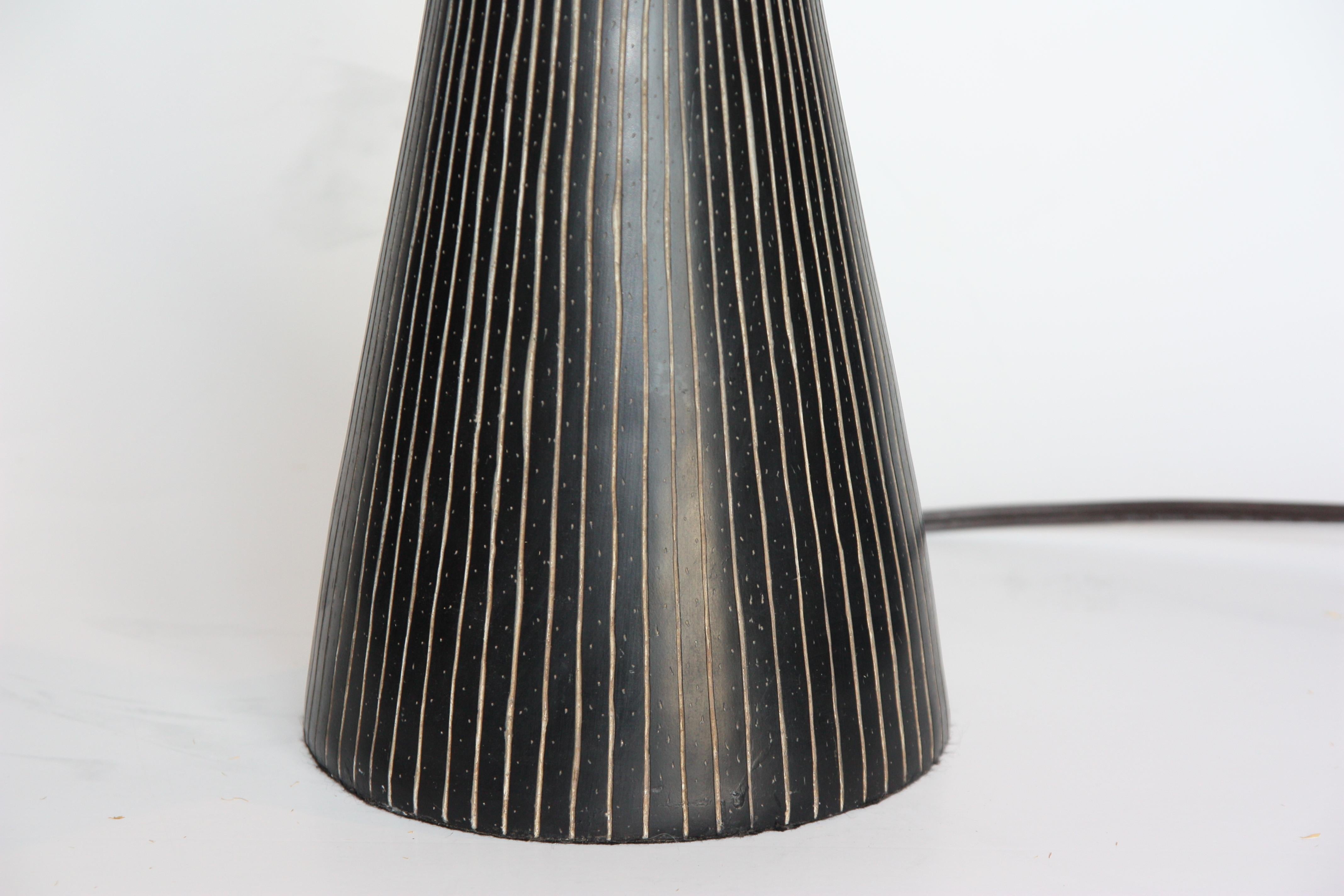 Carved black wood lamp with vertical lines and original finial. Original grasscloth shade included.