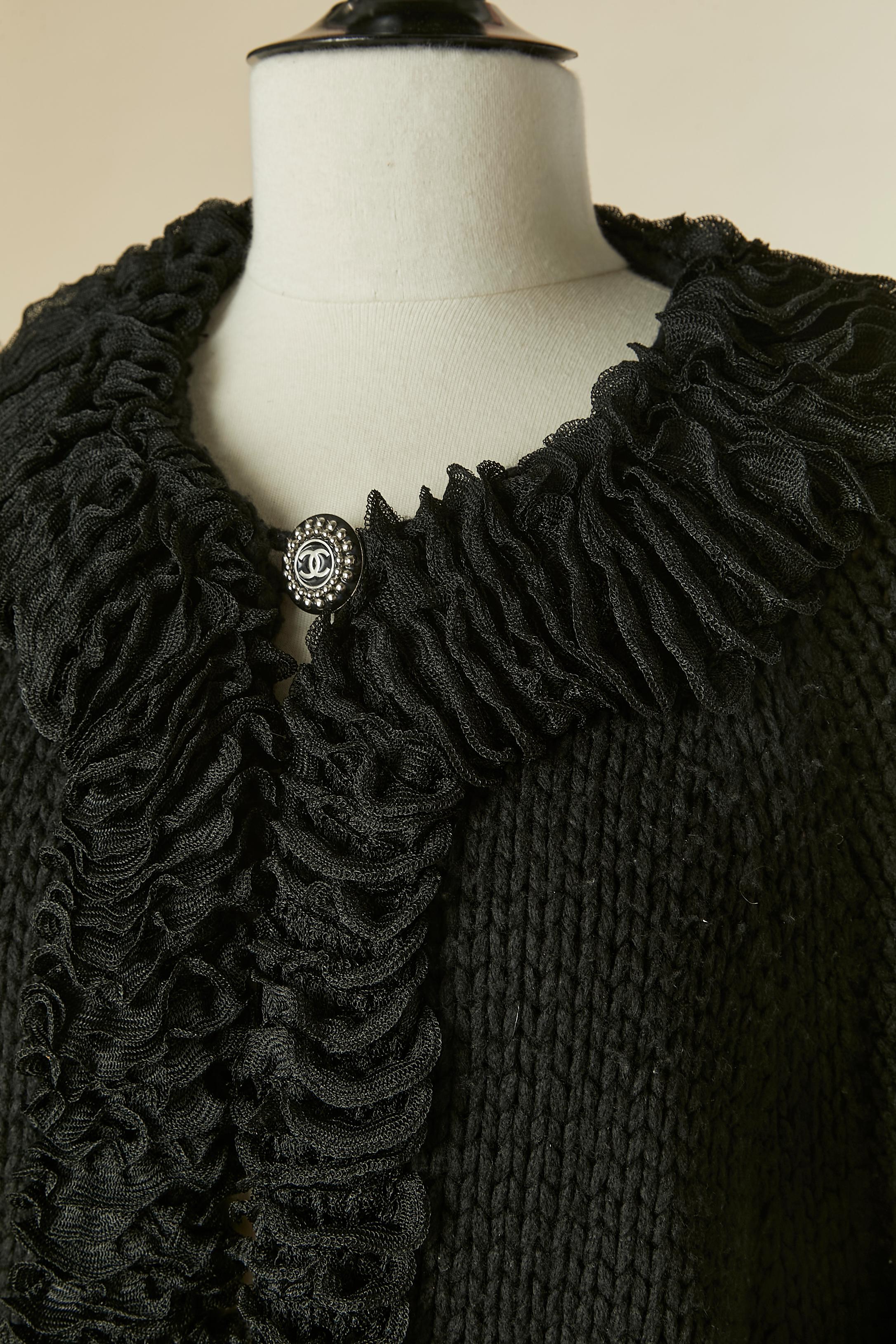 Cardigan en cachemire noir avec bord à volants et fermeture par un bouton de marque sur le milieu du devant. 
Composition du tricot : 82% cachemire, 18% polyester. 
Poche sur les deux côtés 
TAILLE 46 (I.L.A) L