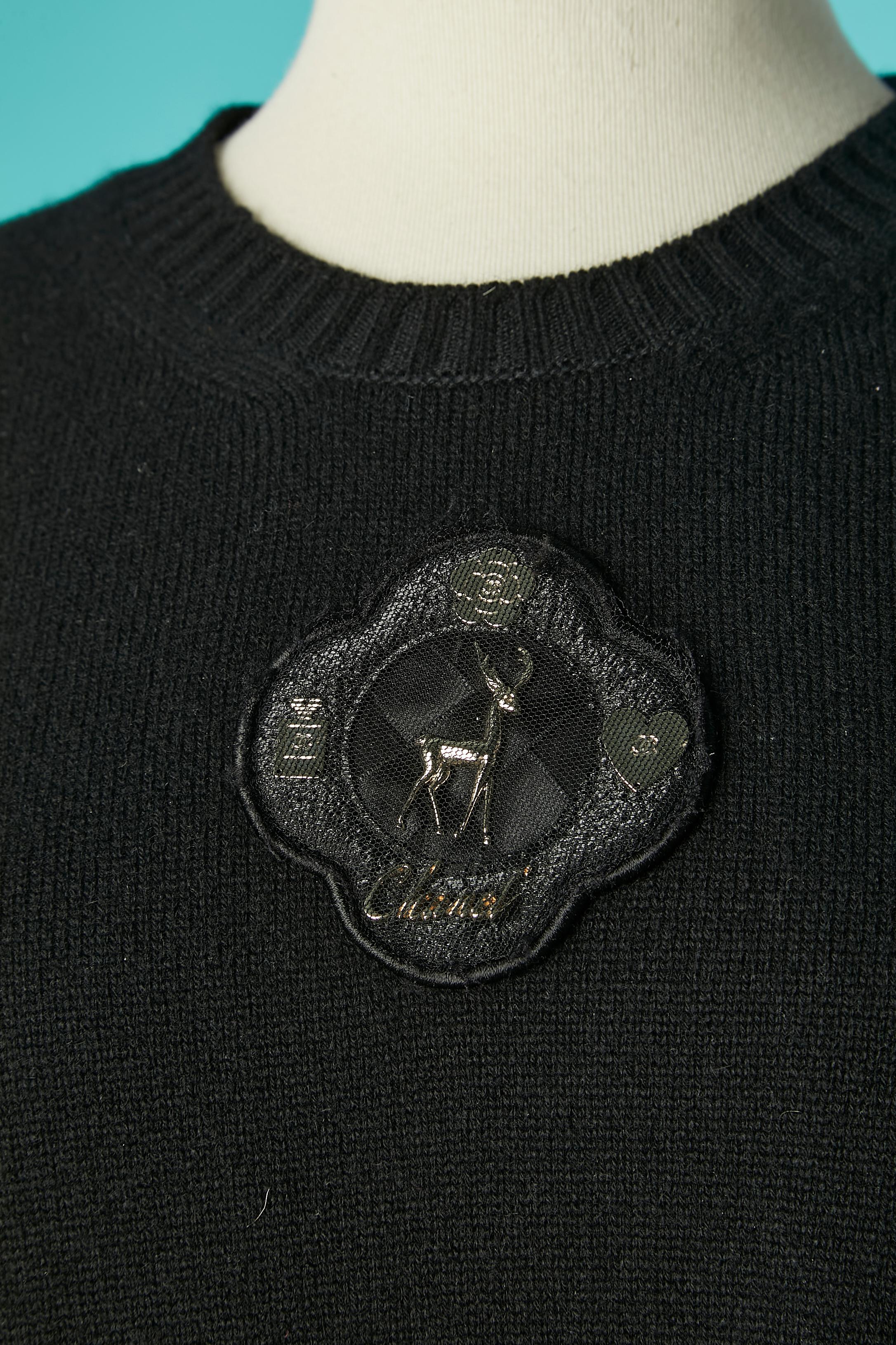 Black cashmere knit dress with short sleeve and embellishment in the top middle front covered with tulle. Branded buttons and buttonholes on the pockets. 
SIZE 46 (Fr) 16 (US) 