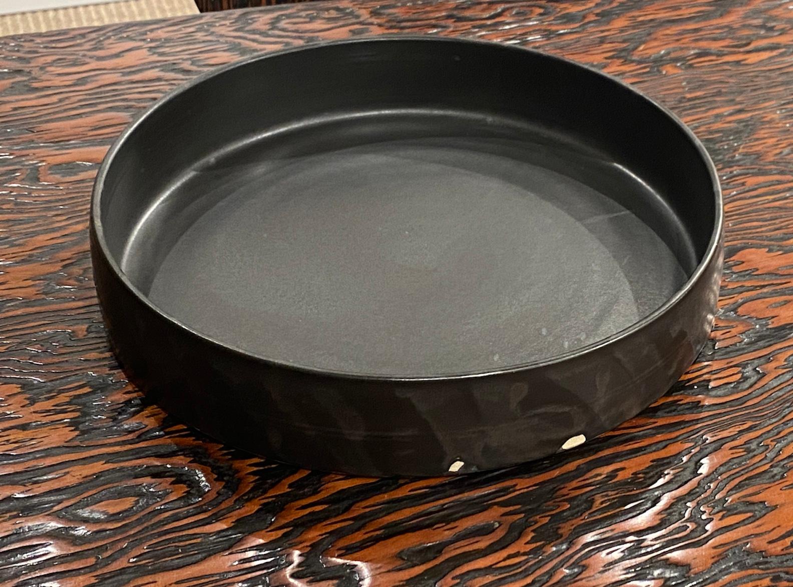 Ce plat en céramique émaillée noire fabriqué à la main est une pièce unique réalisée par un artiste céramiste britannique des Cotswolds. 