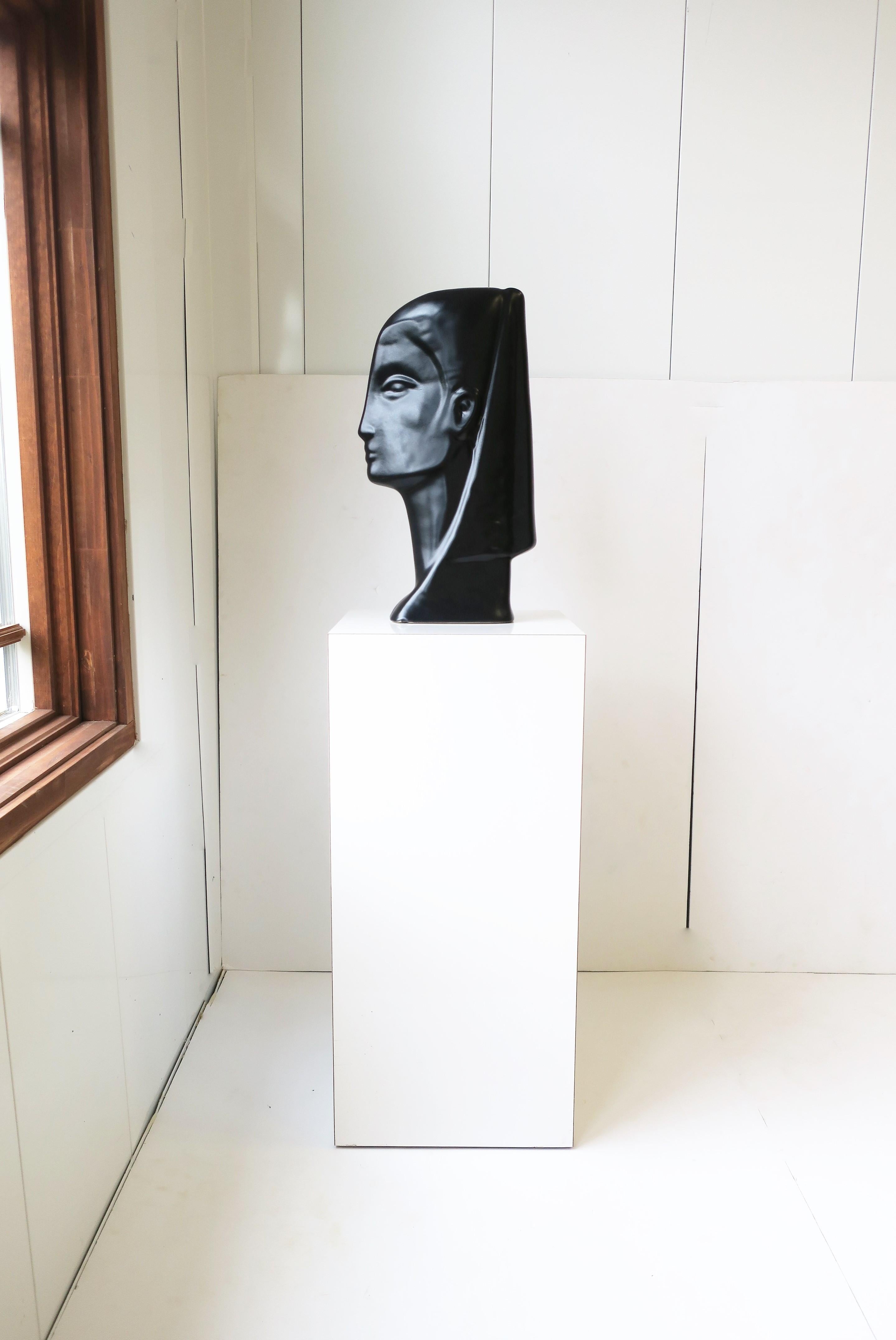 A striking vintage black ceramic pottery female face bust sculpture, circa 20th century. A great piece for a column pedestal as shown, shelf, mantle, cocktail table, credenza, etc. Very good condition as shown in mages. No chips noted. Sculpture is