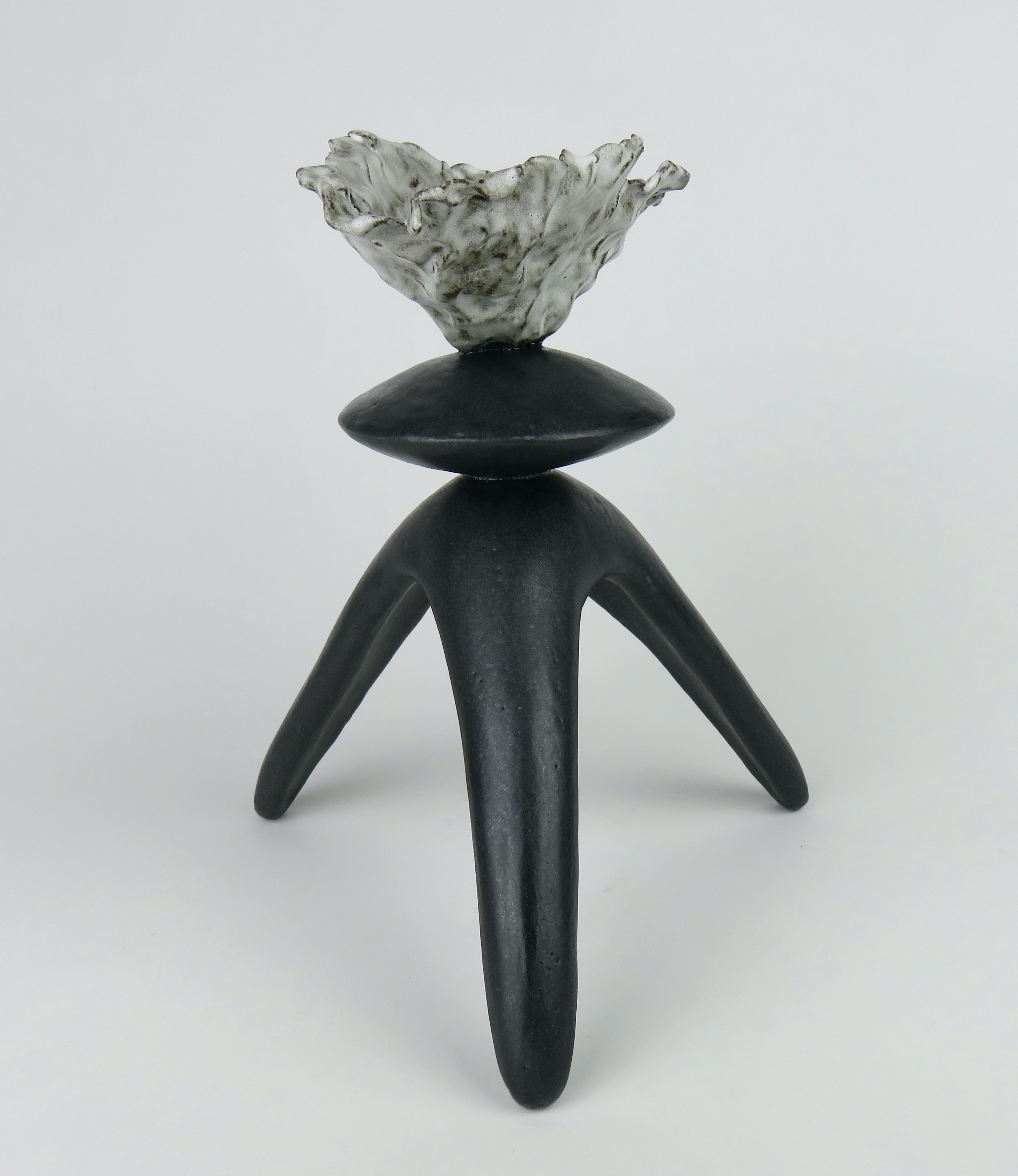 Ce TOTEM moderne en céramique émaillée noire fabriqué à la main se compose d'un sommet ouvert de forme libre avec une forme sphérique centrale sur des pieds tripodes. Fait partie d'une série d'œuvres totémiques modernes. 
L'argile en grès brun