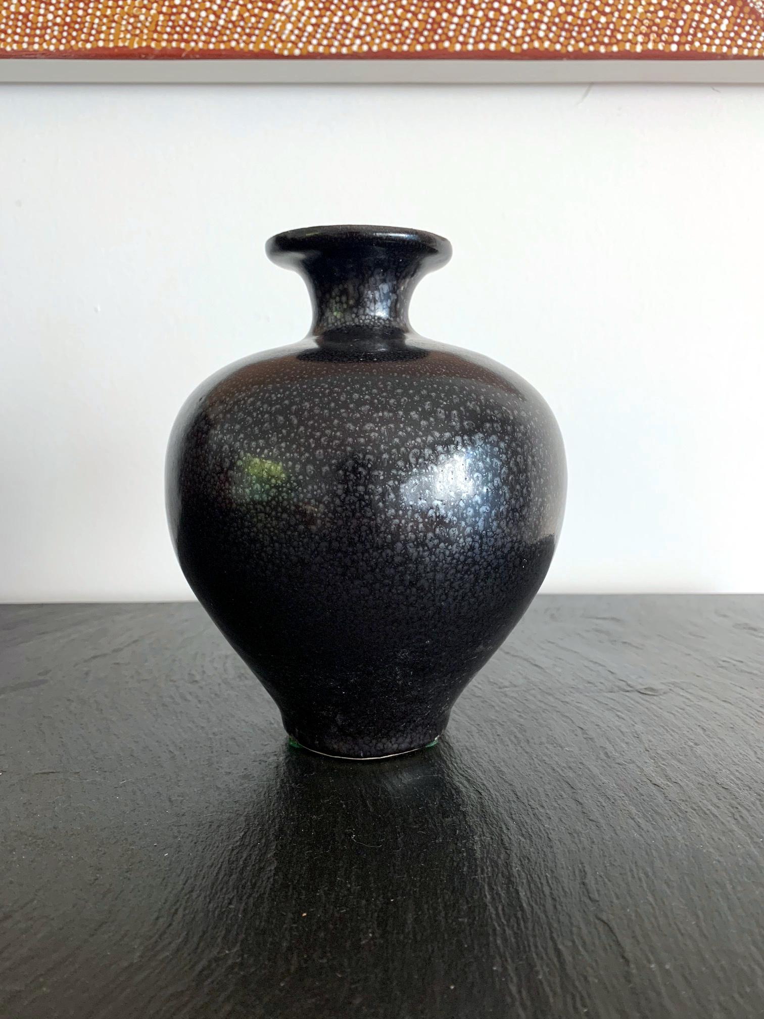 An elegant bulbous vase in classic form, potted from a whitish clay and glazed in a polished black. The oil-spot effect was applied evenly to the black surface, in the typical manner of Jian Ware (Jianzhou Kilns of Fujian Province) of Song dynasty
