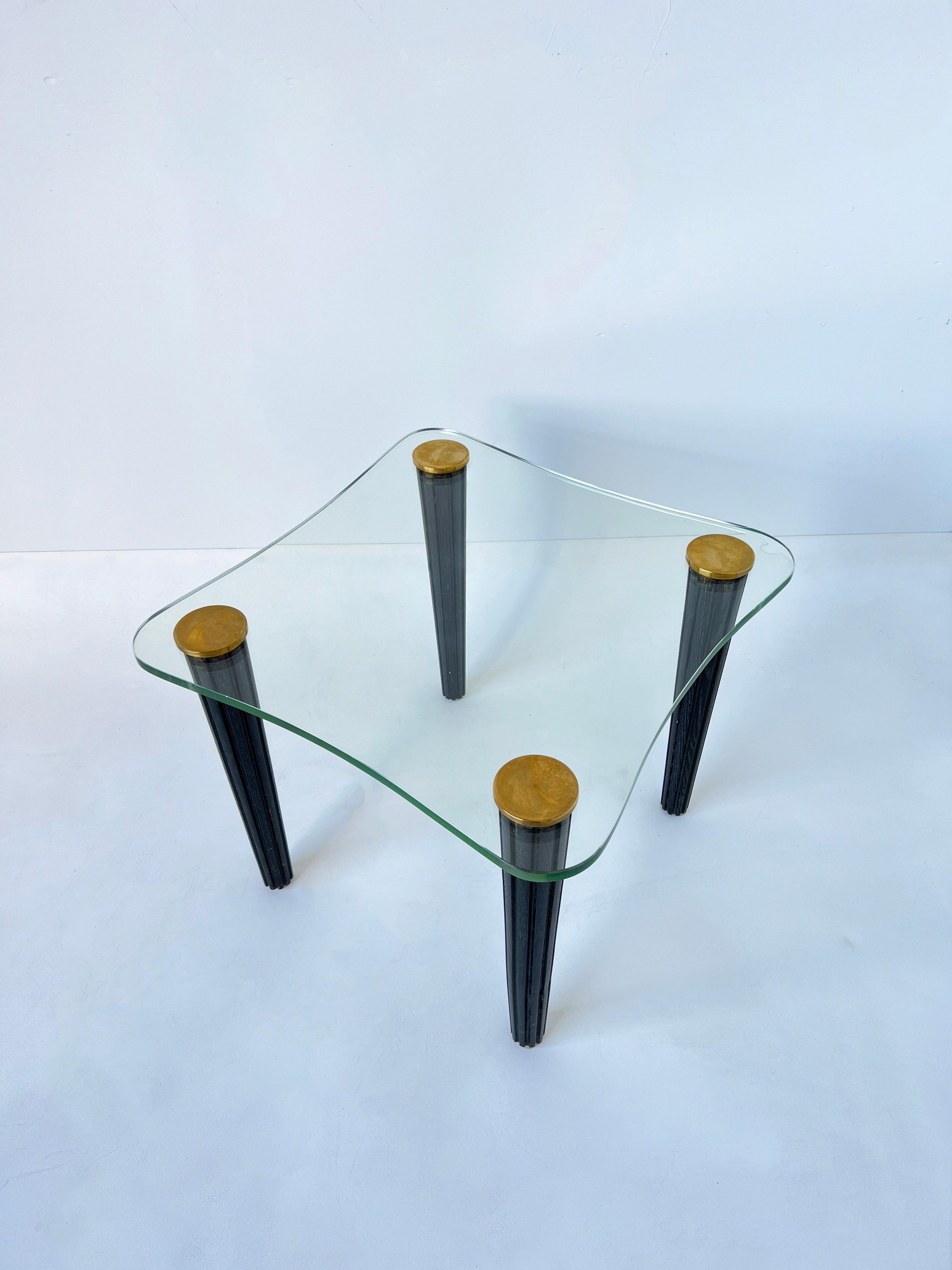 Beautiful 1940s freeform side table by Gilbert Rohde. 
The legs are black Cerused oak and unfinished brass caps hold the original green lead freeform glass top. 
In beautiful original condition, shows minor wear consistent with age.