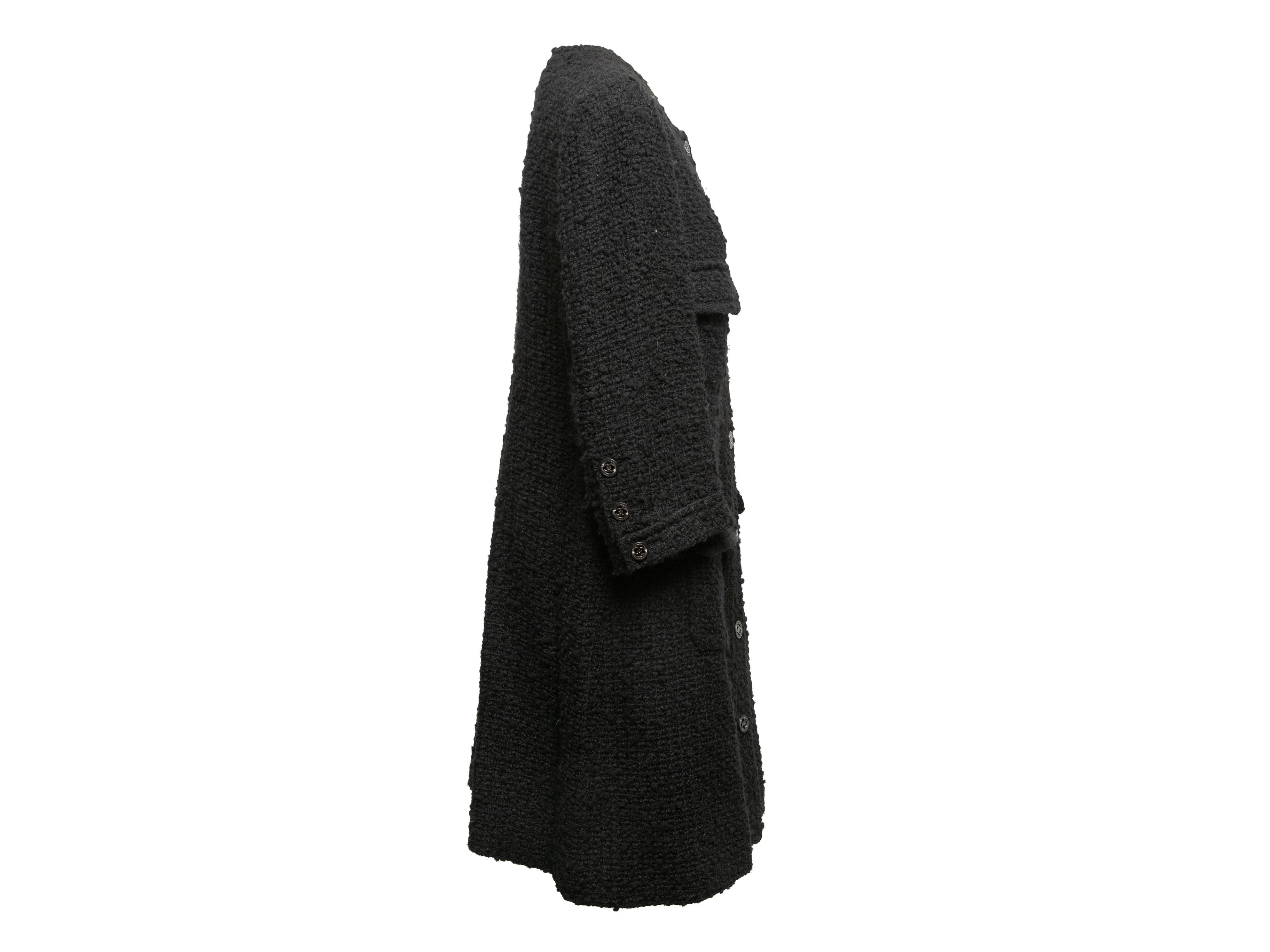 Black boucle wool long coat by Chanel. Crew neck. Four flap pockets. Front button closures. 42