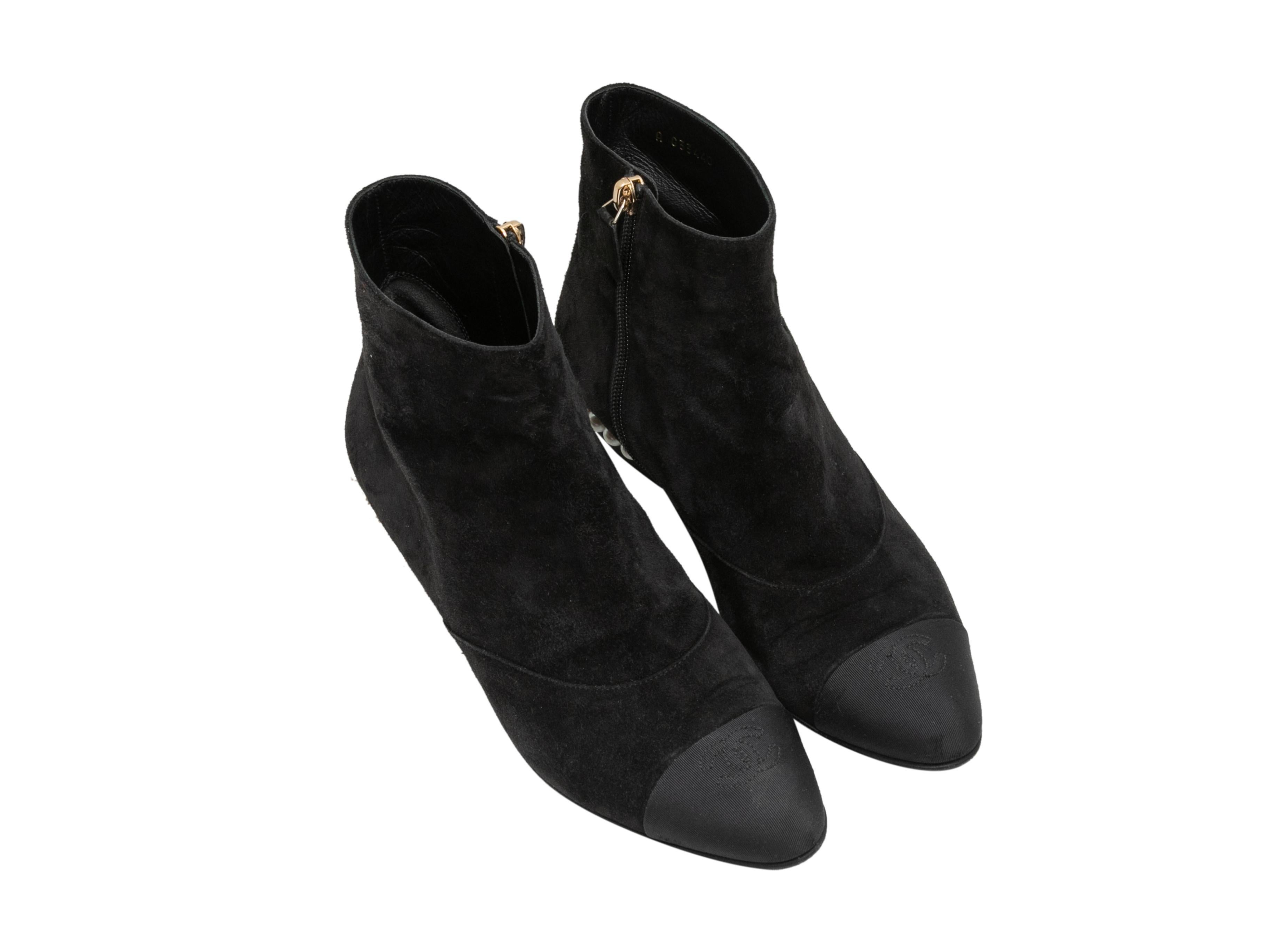 Black suede cap-toe ankle boots by Chanel. Faux pearl accents at grosgrain block heels. Zip closures at inner sides. 5