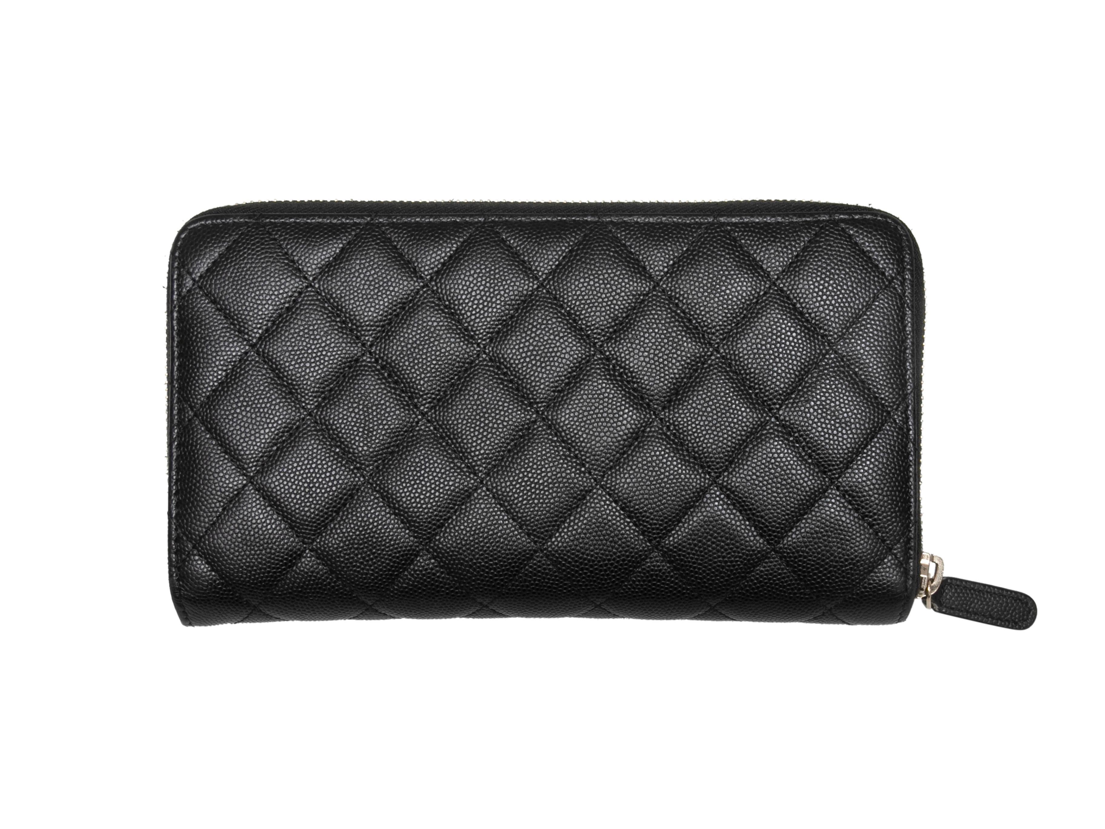 Black caviar leather quilted continental wallet by Chanel. Circa 2018-2019 Gold-tone hardware. Multiple interior card and cash slots. Top zip closure. 8
