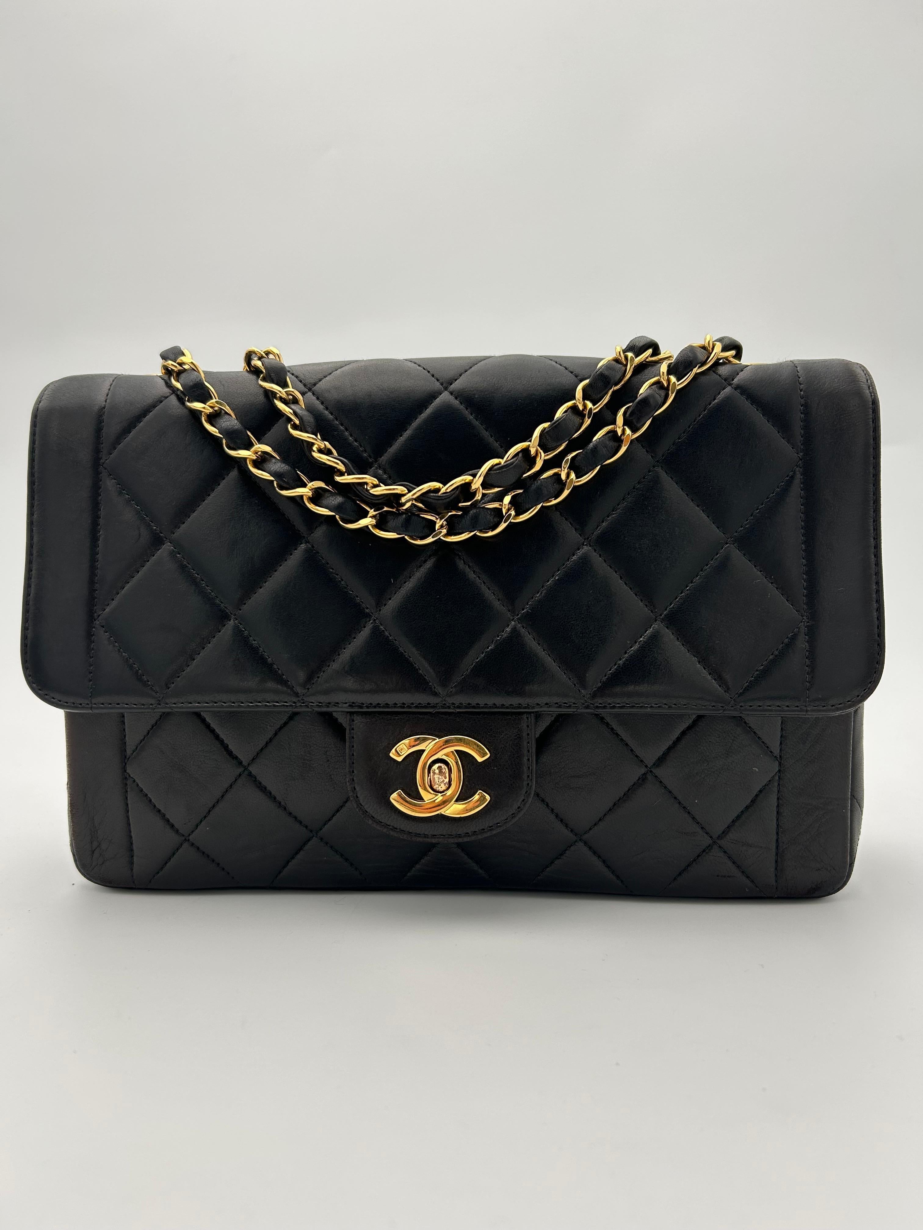Sac à rabat classique Chanel noir. 
Le sac à rabat classique noir de Chanel, en cuir d'agneau matelassé et orné de ferrures dorées, est l'un des sacs à main de luxe les plus emblématiques au monde - un symbole d'élégance et de sophistication