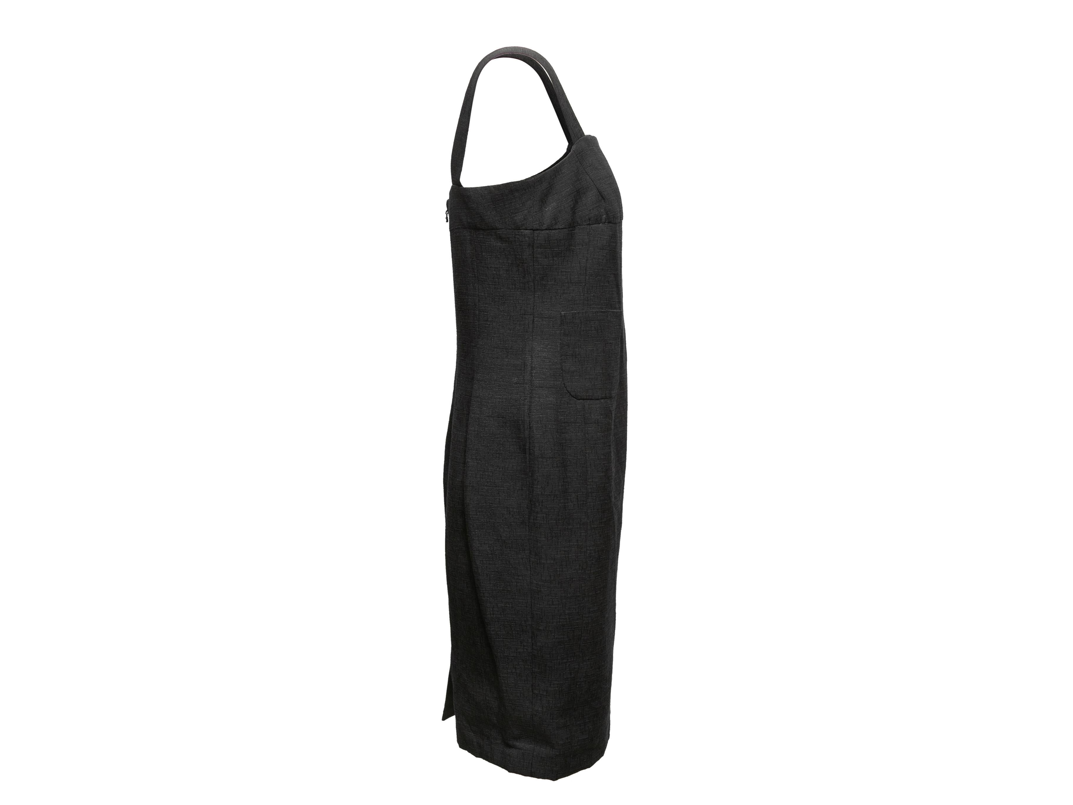 Black sleeveless knee-length dress by Chanel. From the Cruise 2012 Collection. Square neckline. Dual front patch pockets. Zip closure at back. 31