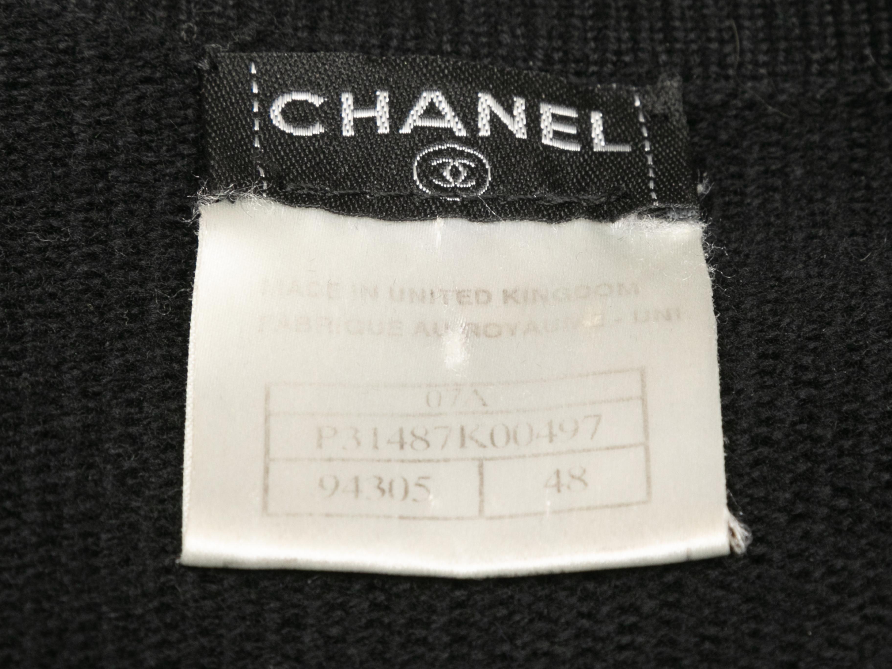 Black longline cashmere cardigan by Chanel. From the Fall/Winter 2007 Collection. V-neck. Dual hip pockets. Button closures at front. 44