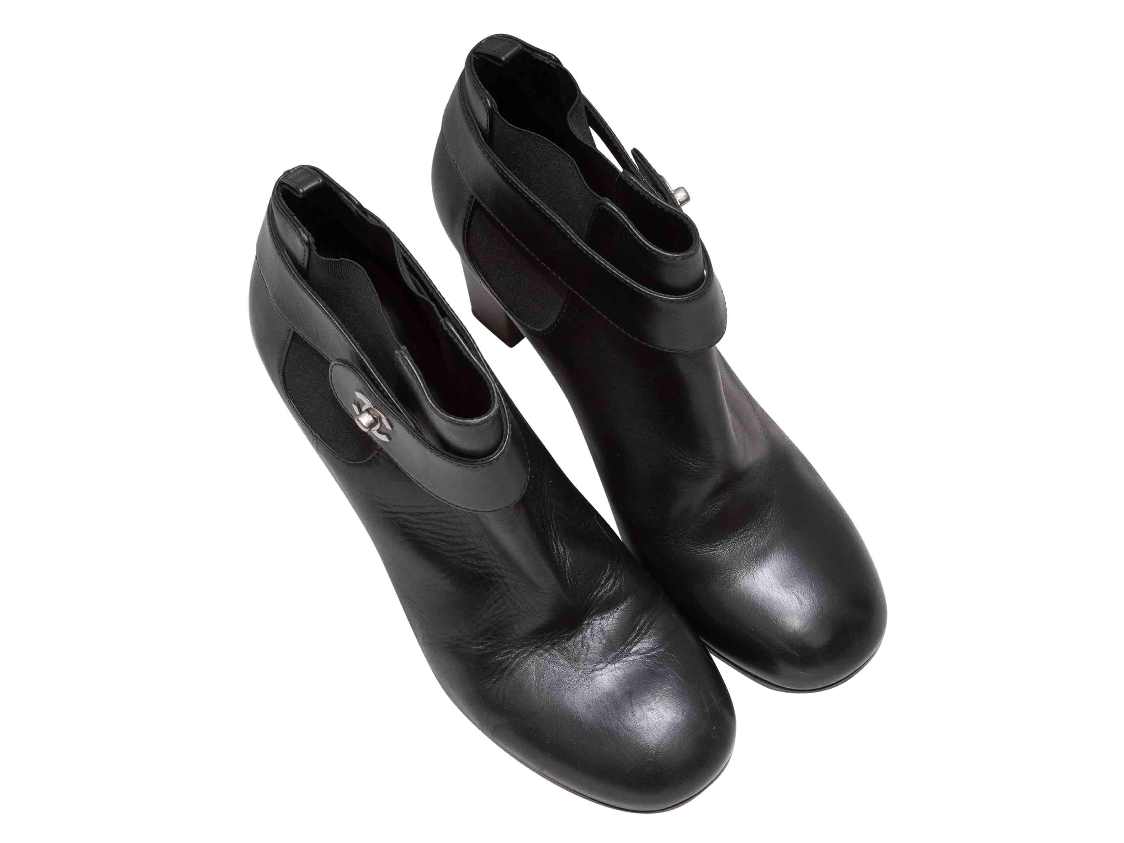 Bottines à talons en cuir noir de Chanel. Talons hauts. Gorge élastiquée sur les côtés. Fermetures CC argentées à la cheville. Hauteur de la tige : 3,5