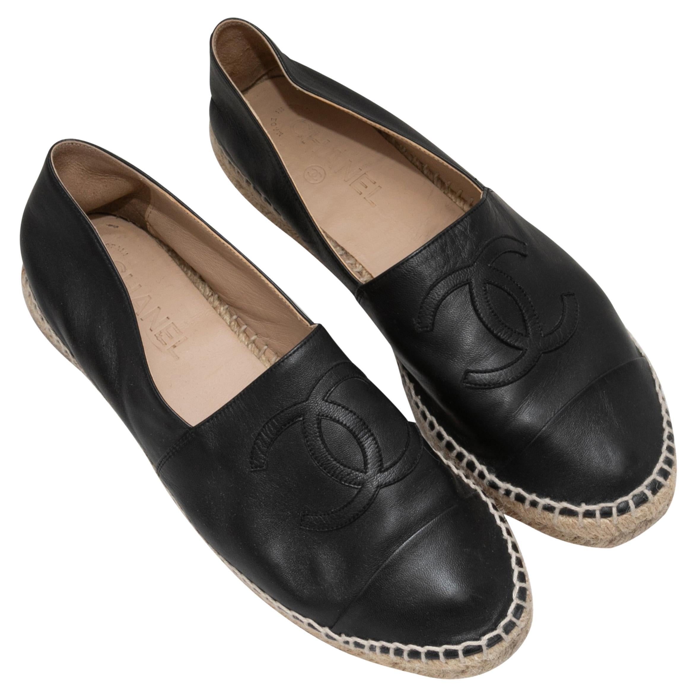 Black leather CC espadrille flats by Chanel. Jute trim at rubber soles. 1