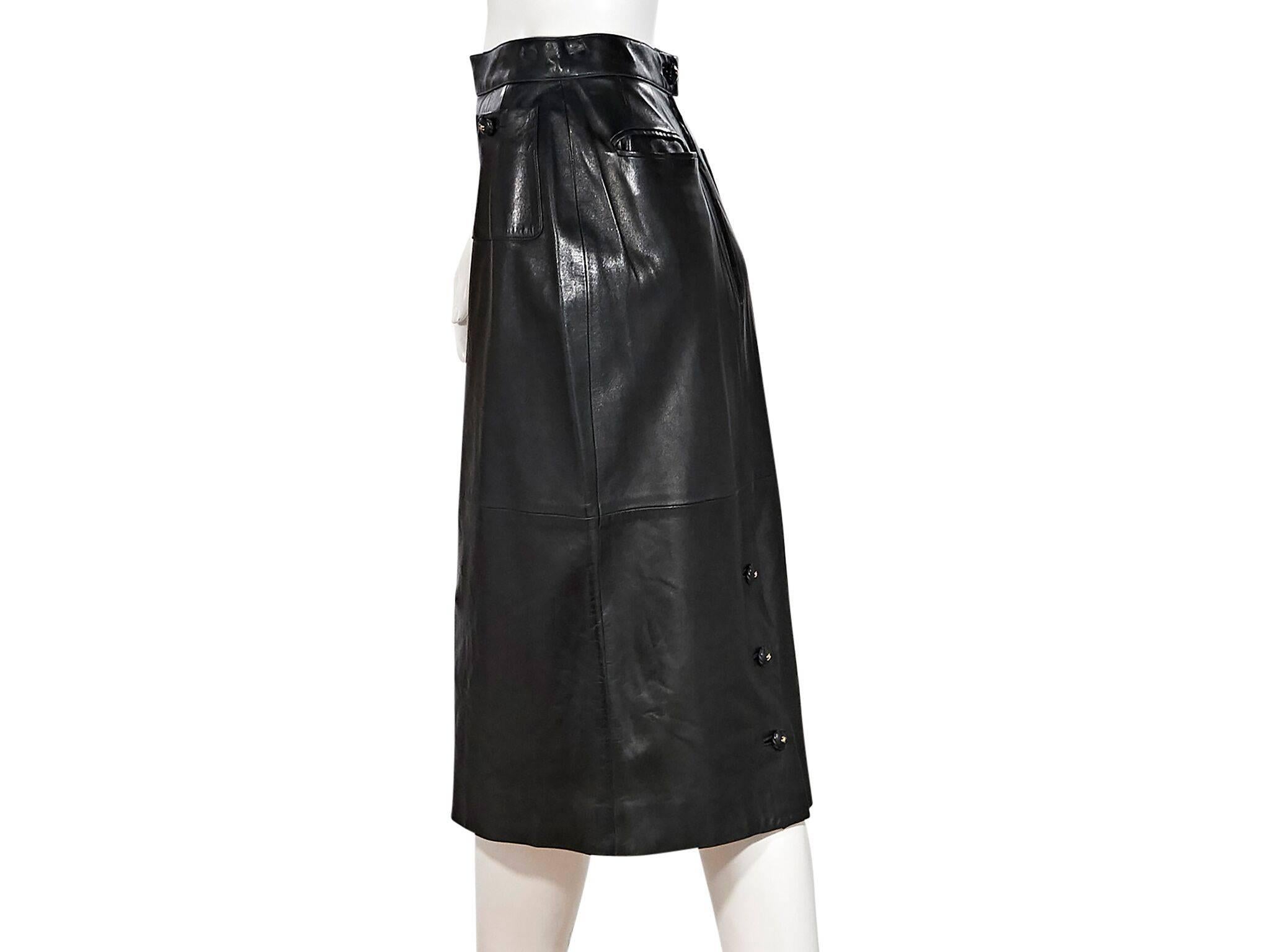 Product details:  Black leather long pencil skirt by Chanel.  Banded waist.  Waist button patch pockets.  Back button with concealed zip closure.  Back besom pockets.  Button back center hem.  28