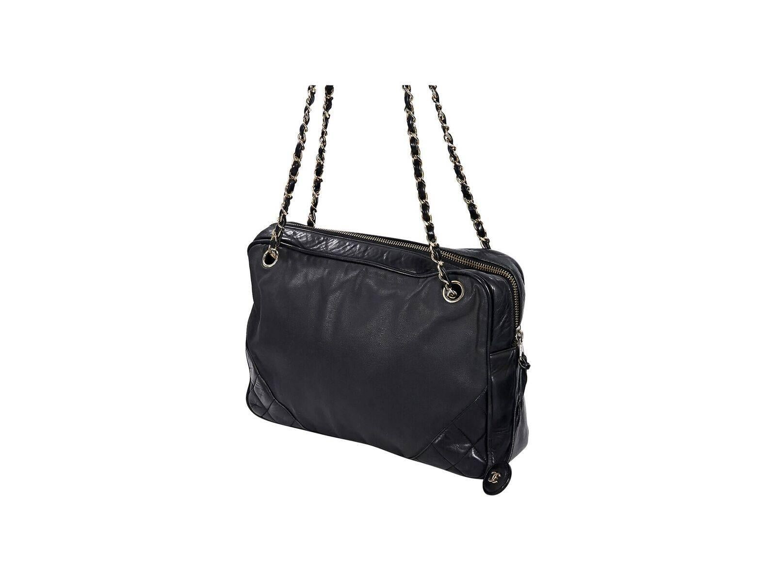 Product details:  Black leather shoulder bag by Chanel.  Accented with quilted corners.  Dual chain and leather shoulder straps.  Top zip closure.  Leather interior with inner slide and zip pockets.  Front exterior slide pocket.  Goldtone hardware. 